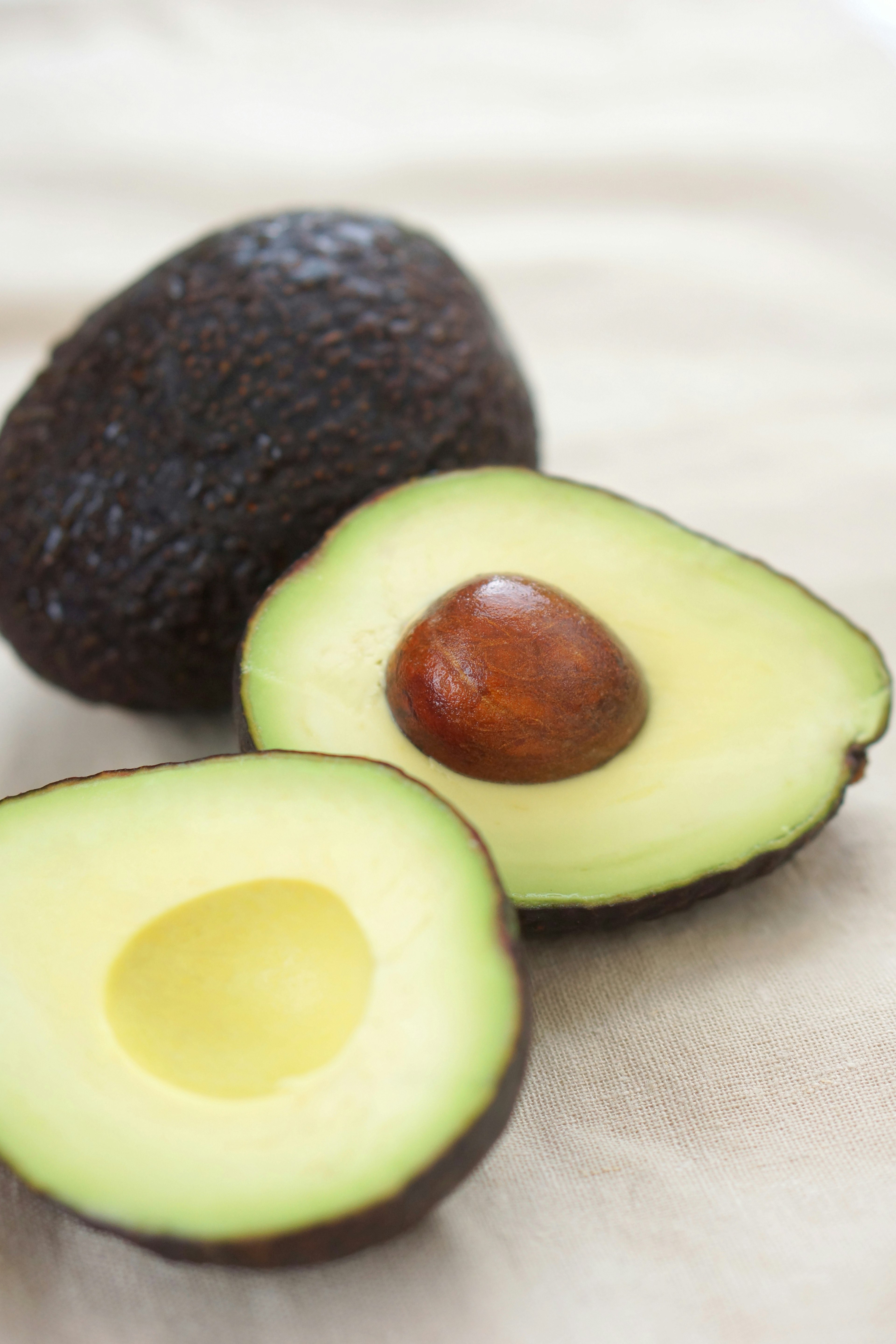 Ripe avocado cut in half with a brown seed