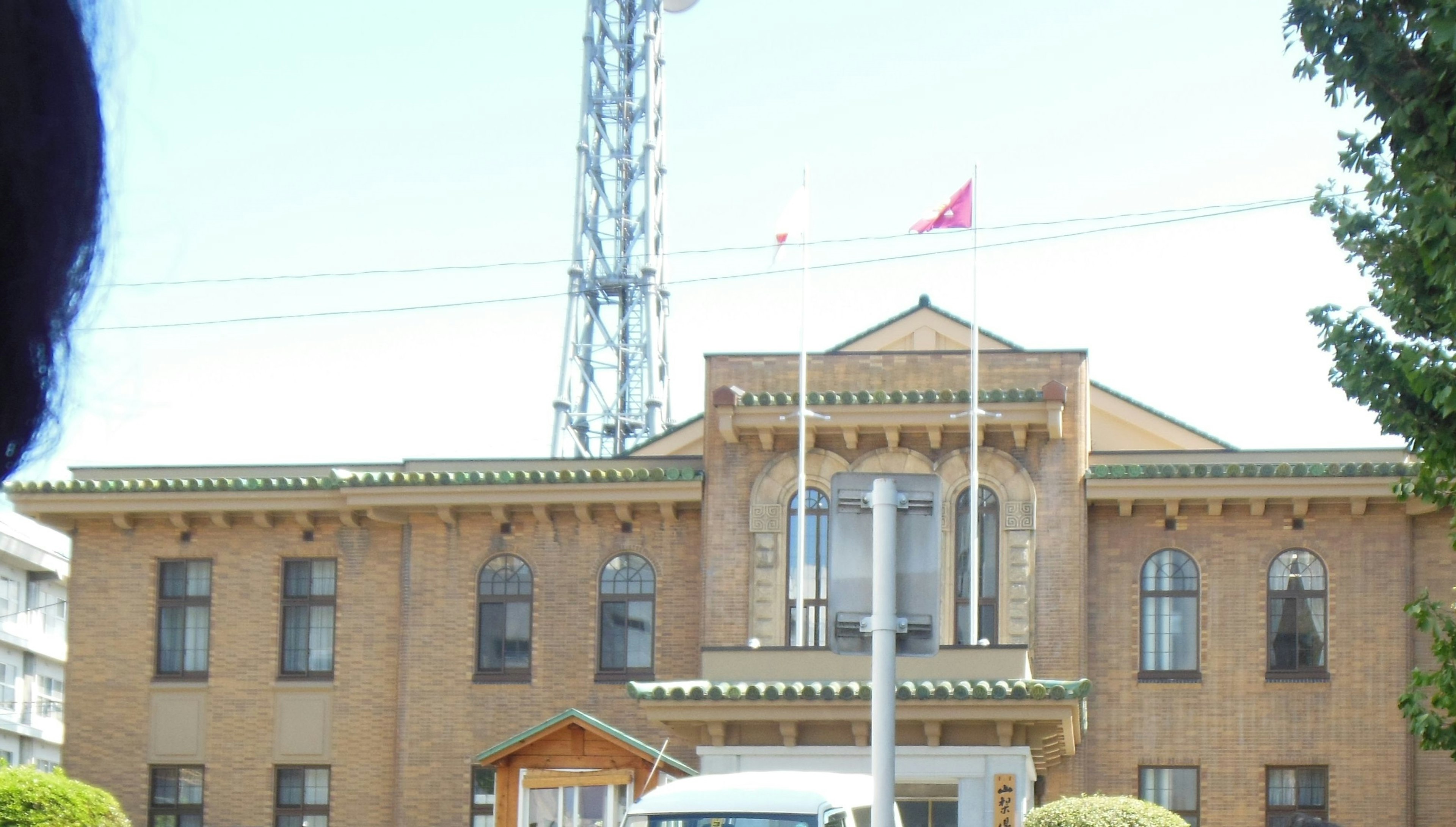 Extérieur d'un bâtiment historique avec un drapeau rouge et une tour de communication