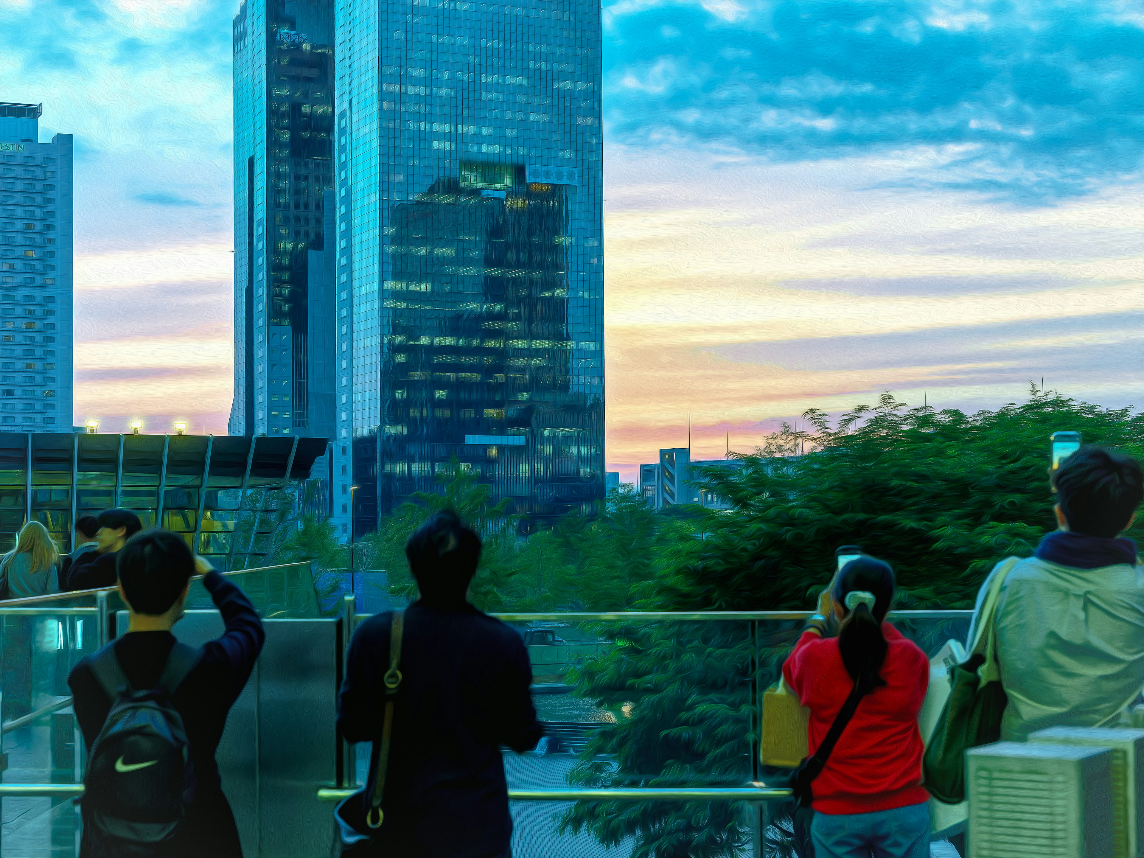 Silhouettes of people taking photos against a sunset cityscape