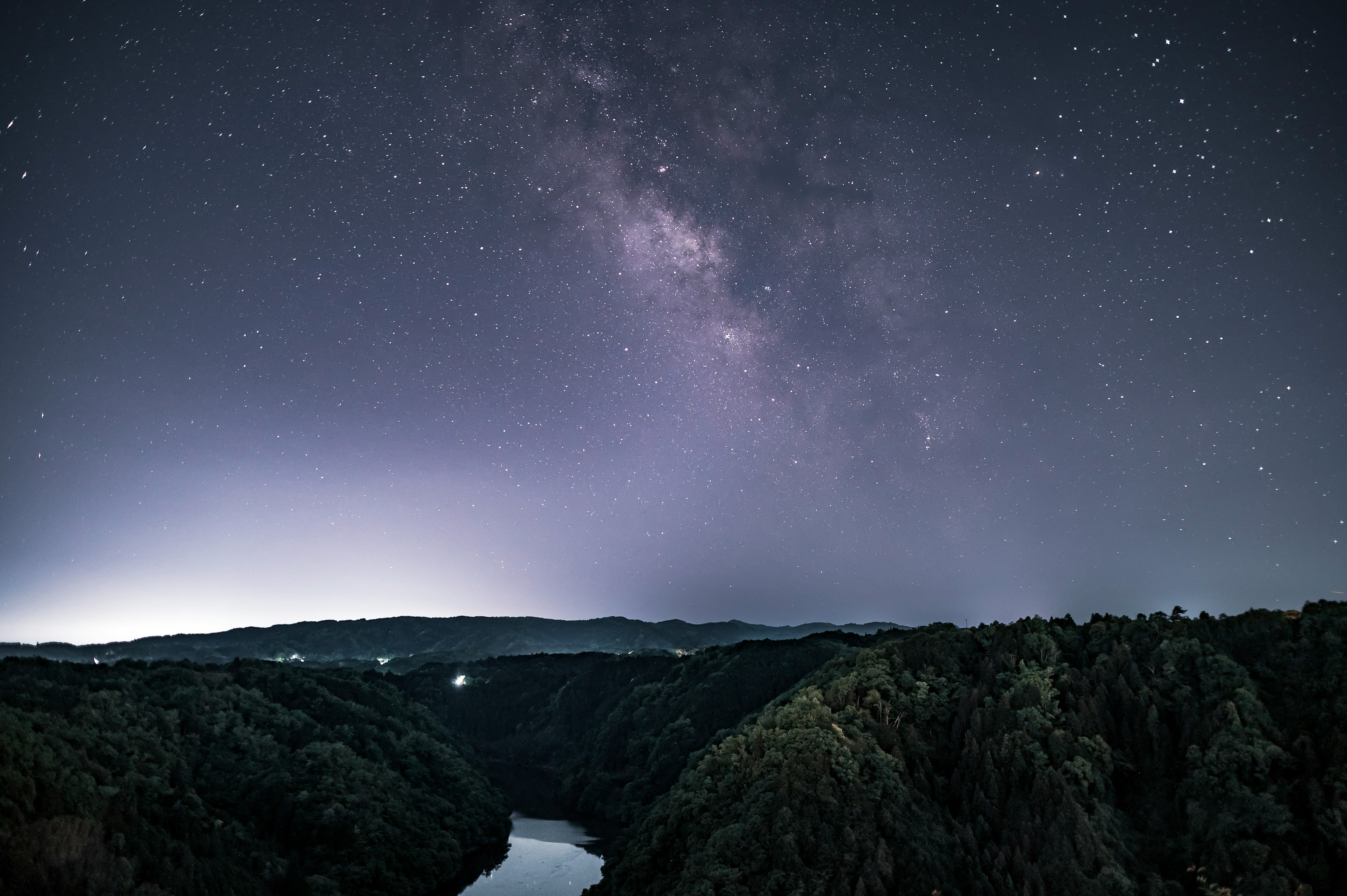 美しい星空と銀河が広がる夜空の風景 雄大な山々と川が見える