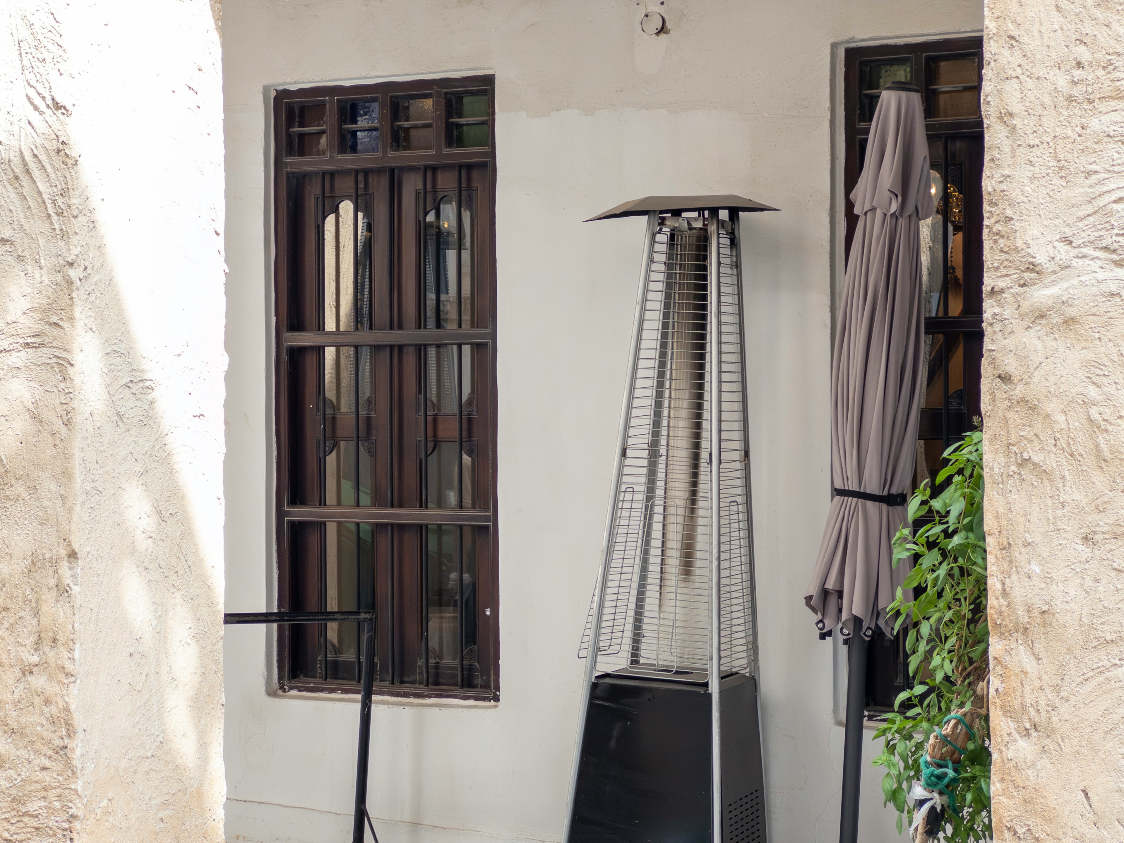 Terrace with windows and a patio heater against a white wall