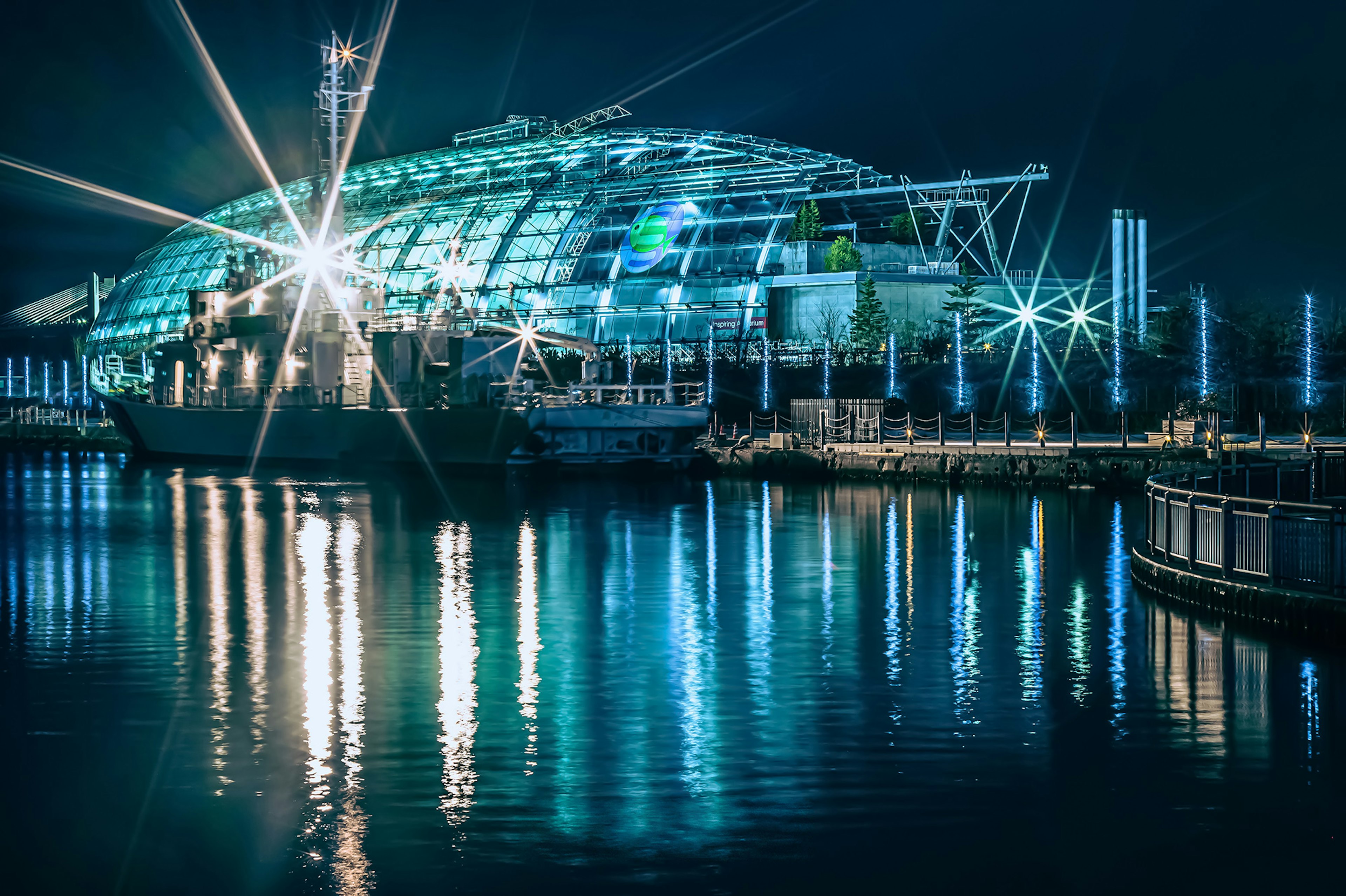 Bâtiment futuriste au bord de l'eau la nuit avec de superbes reflets