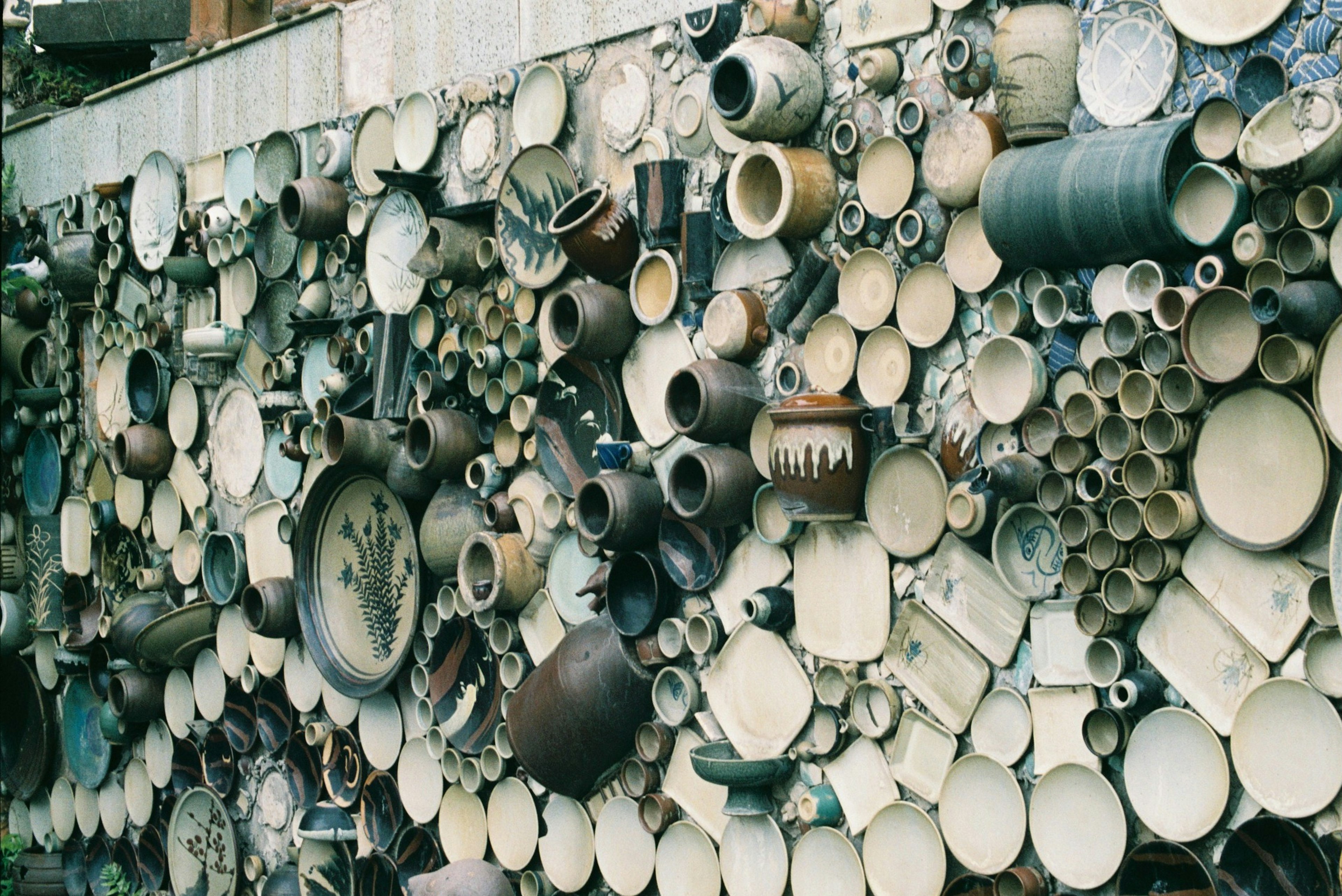 Una collezione di oggetti in ceramica e metallo di varie forme montati su un muro