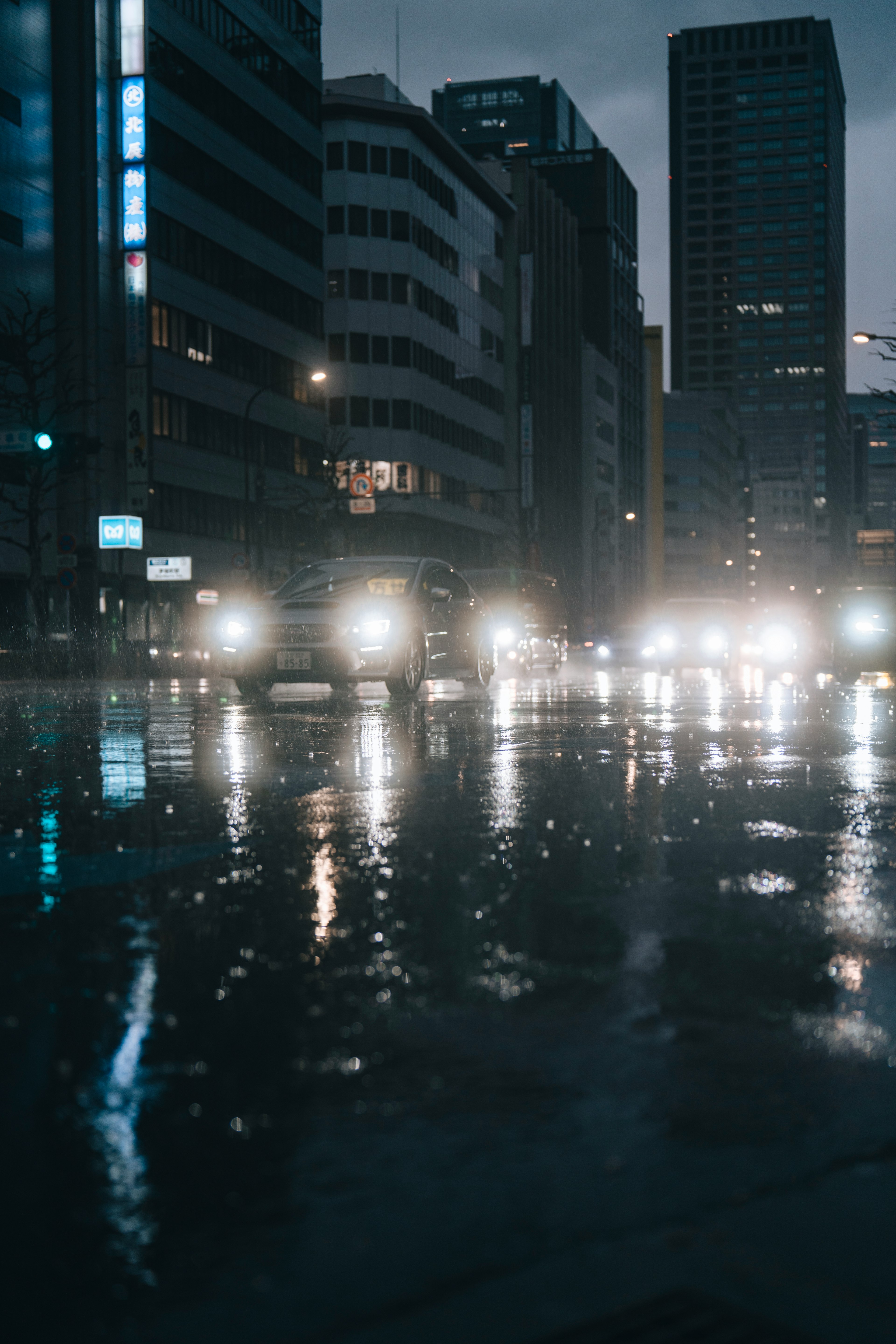 City scene with rain-soaked streets headlights reflecting