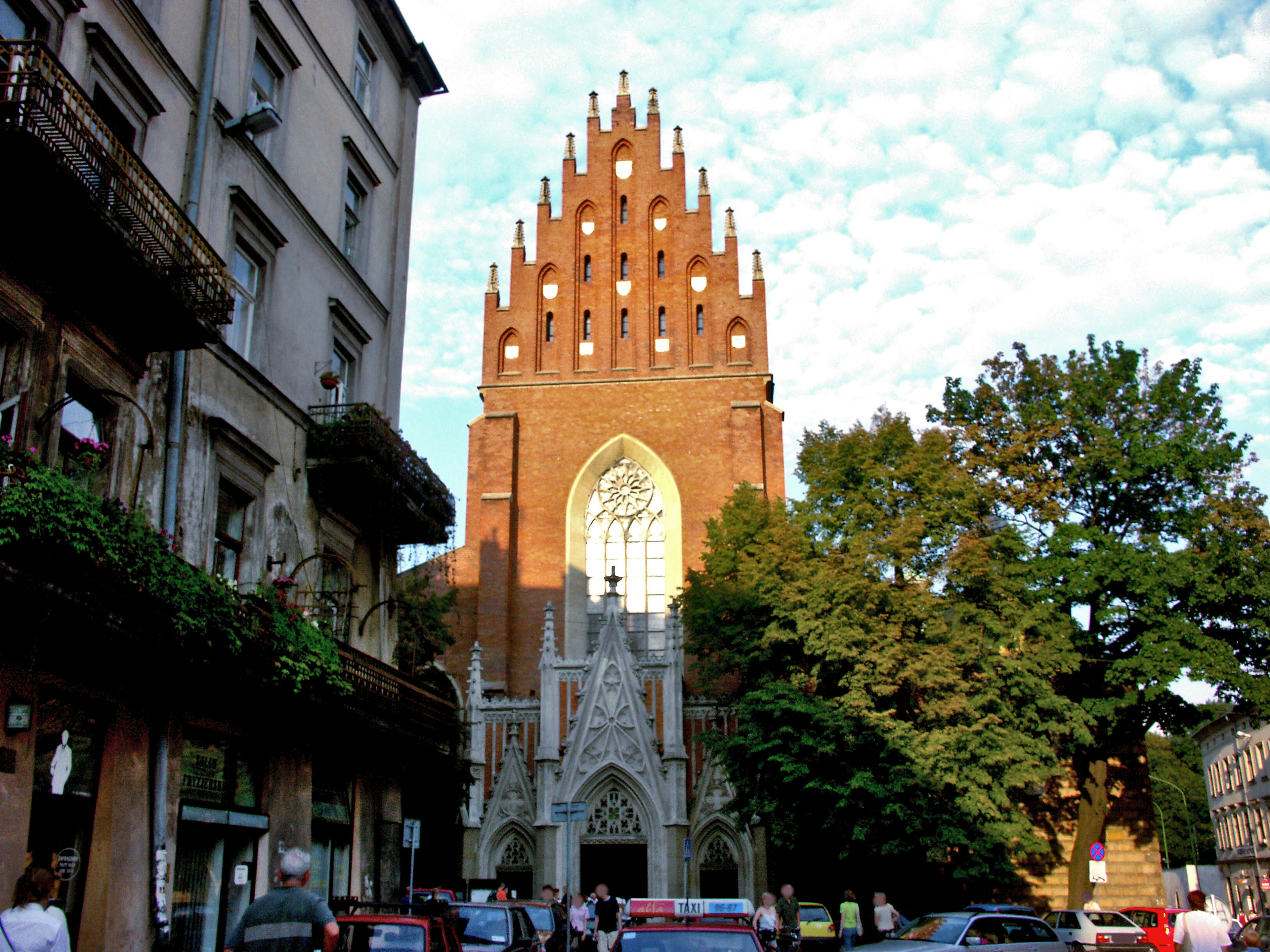 Red brick church with Gothic architecture surrounded by buildings