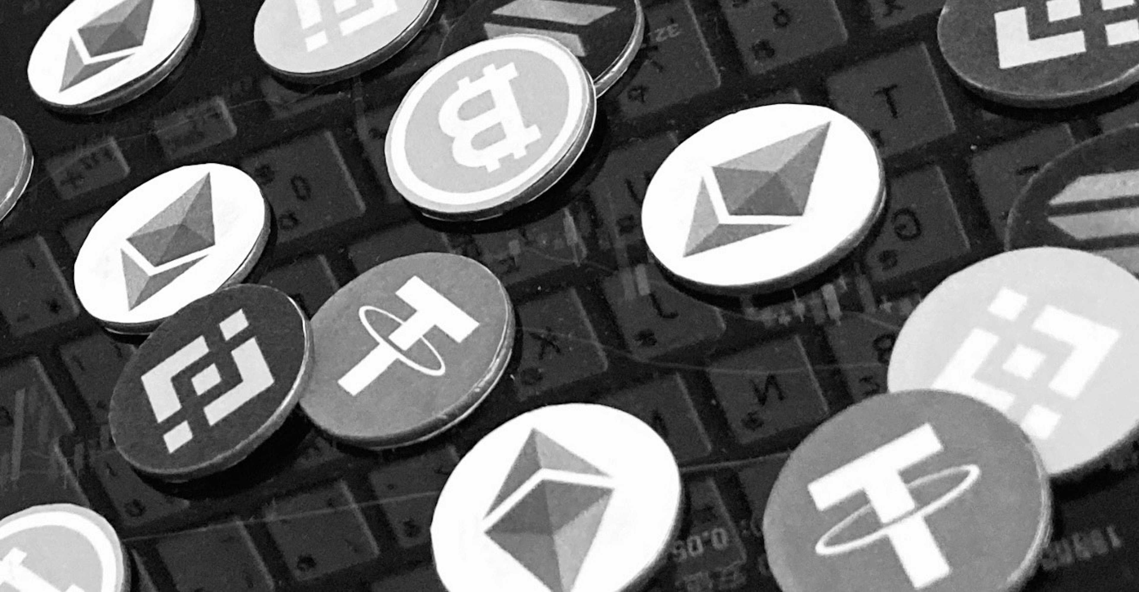 Plusieurs logos de cryptomonnaies disposés sur un fond sombre