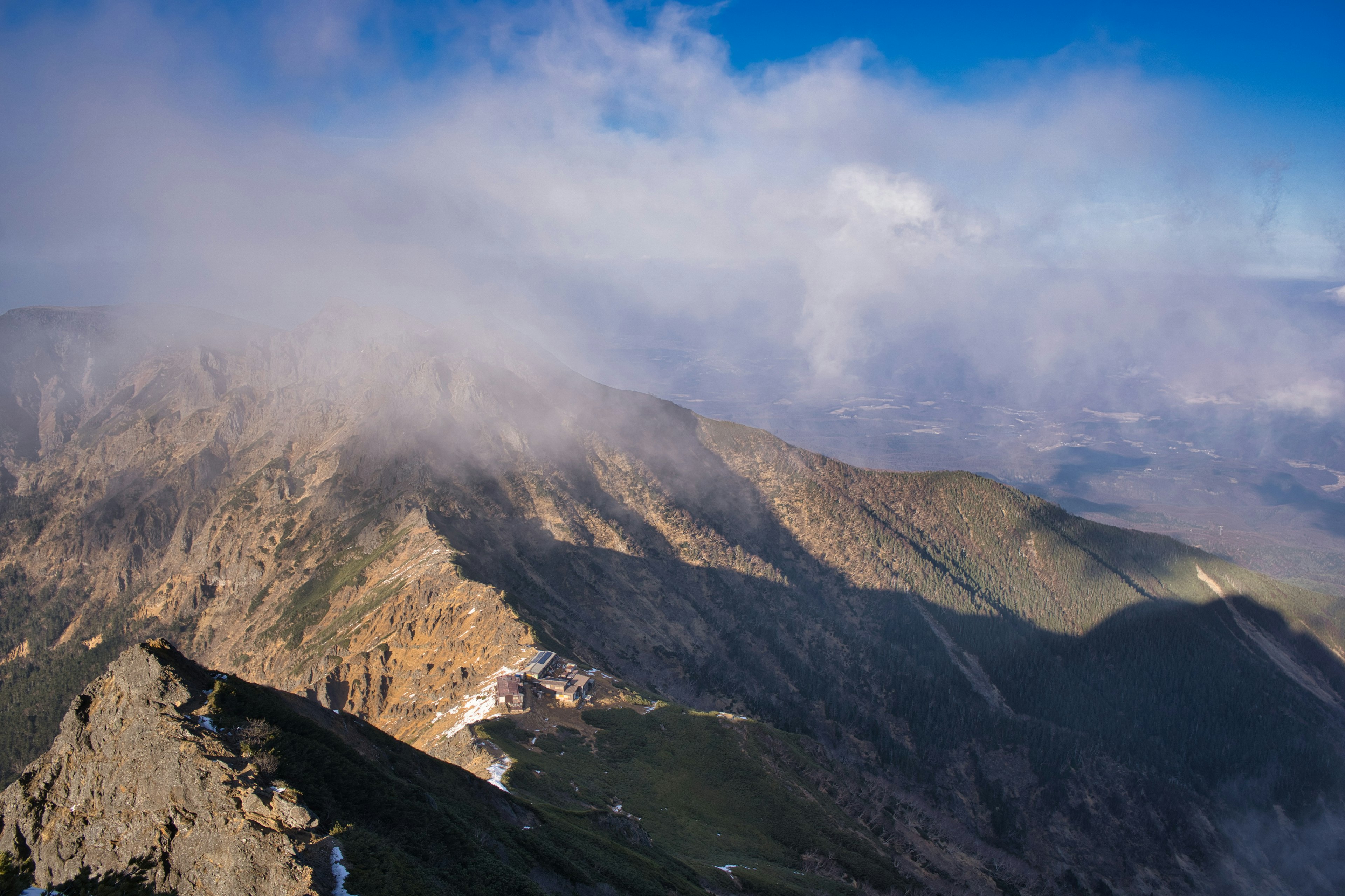 雲に覆われた山の景色と影を持つ山脈