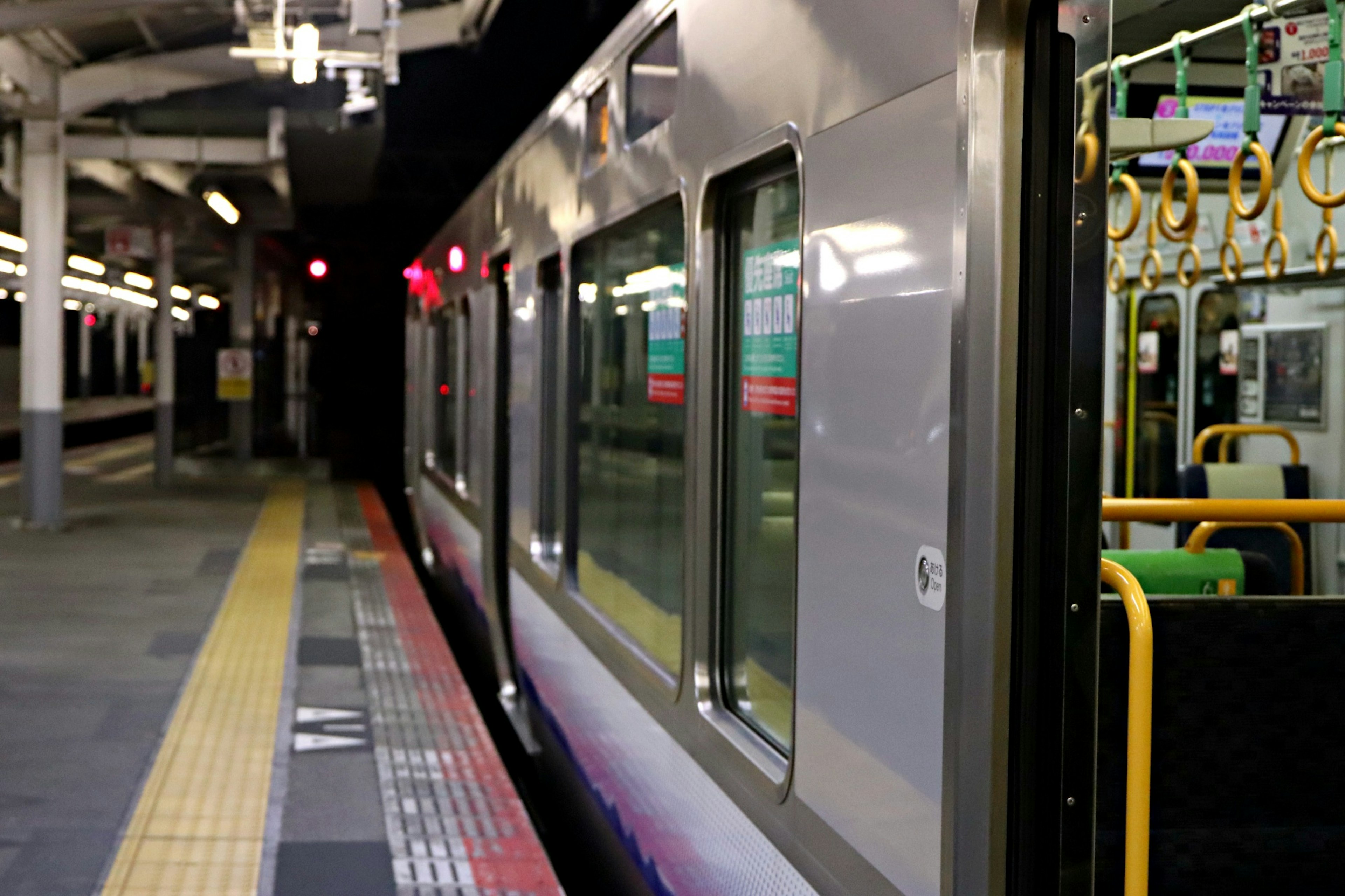 Treno fermo su una banchina con illuminazione notturna in una stazione della metropolitana