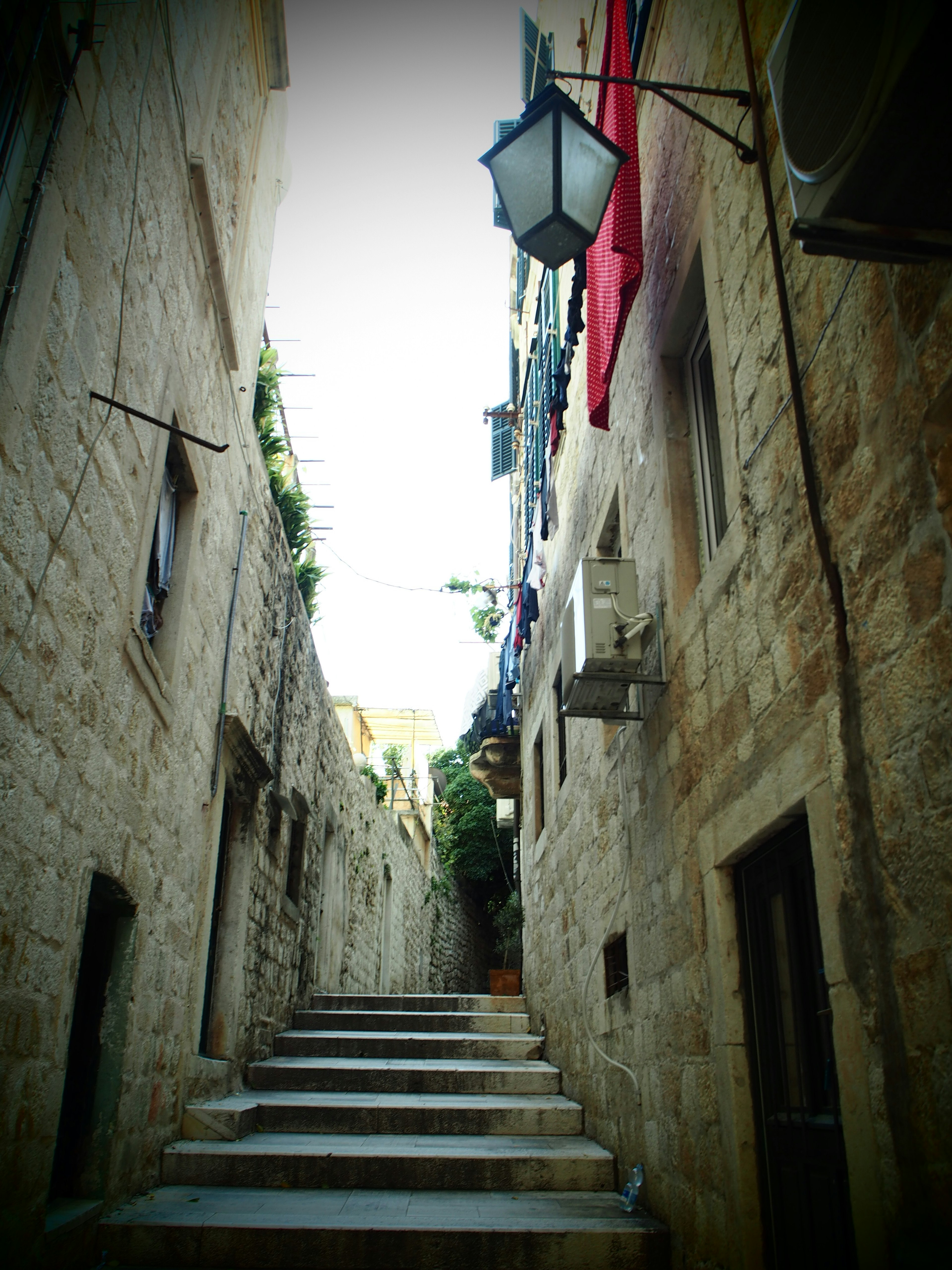 Narrow stone alley with steps and vintage lantern