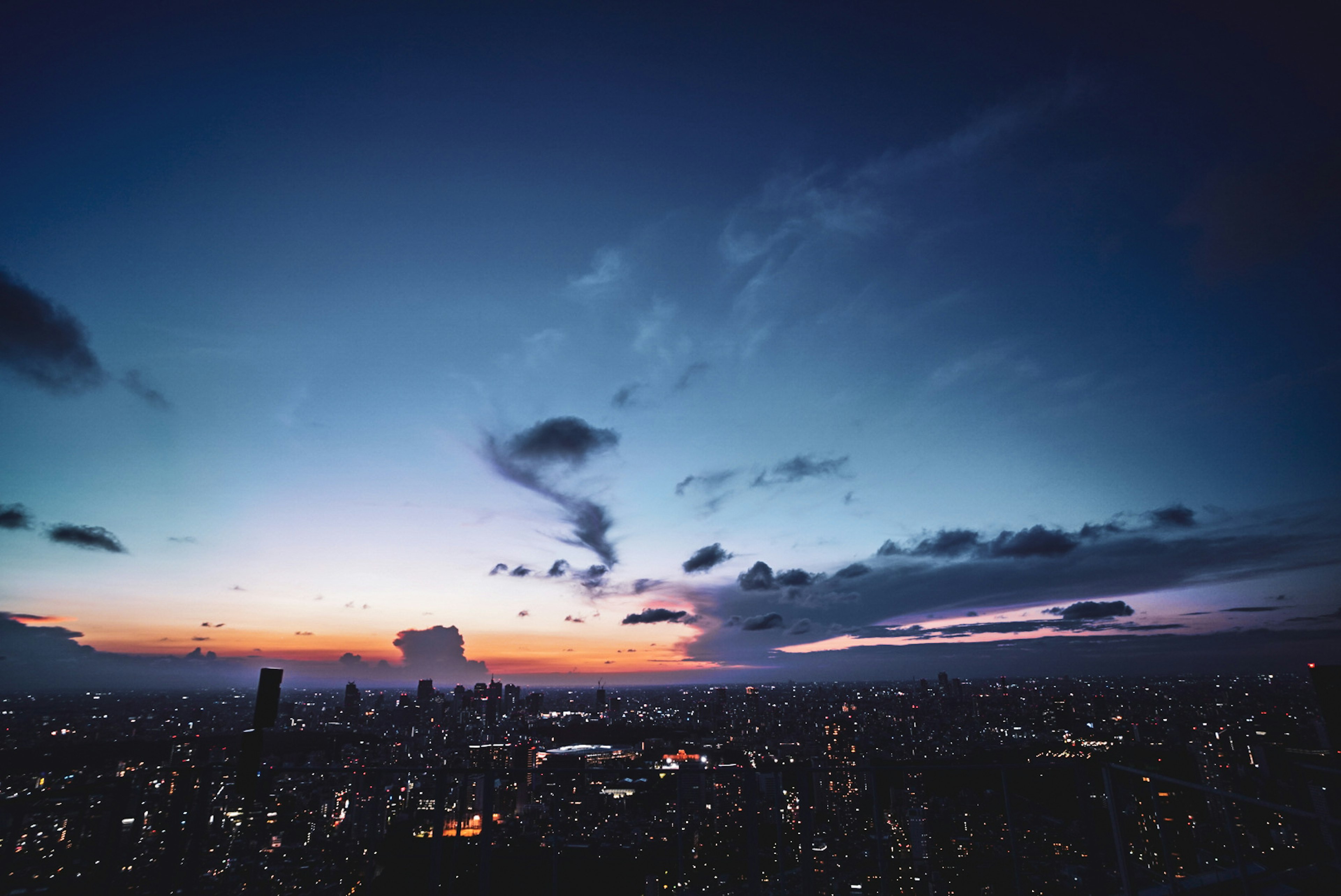 都市の夜明けの風景に青とオレンジの空