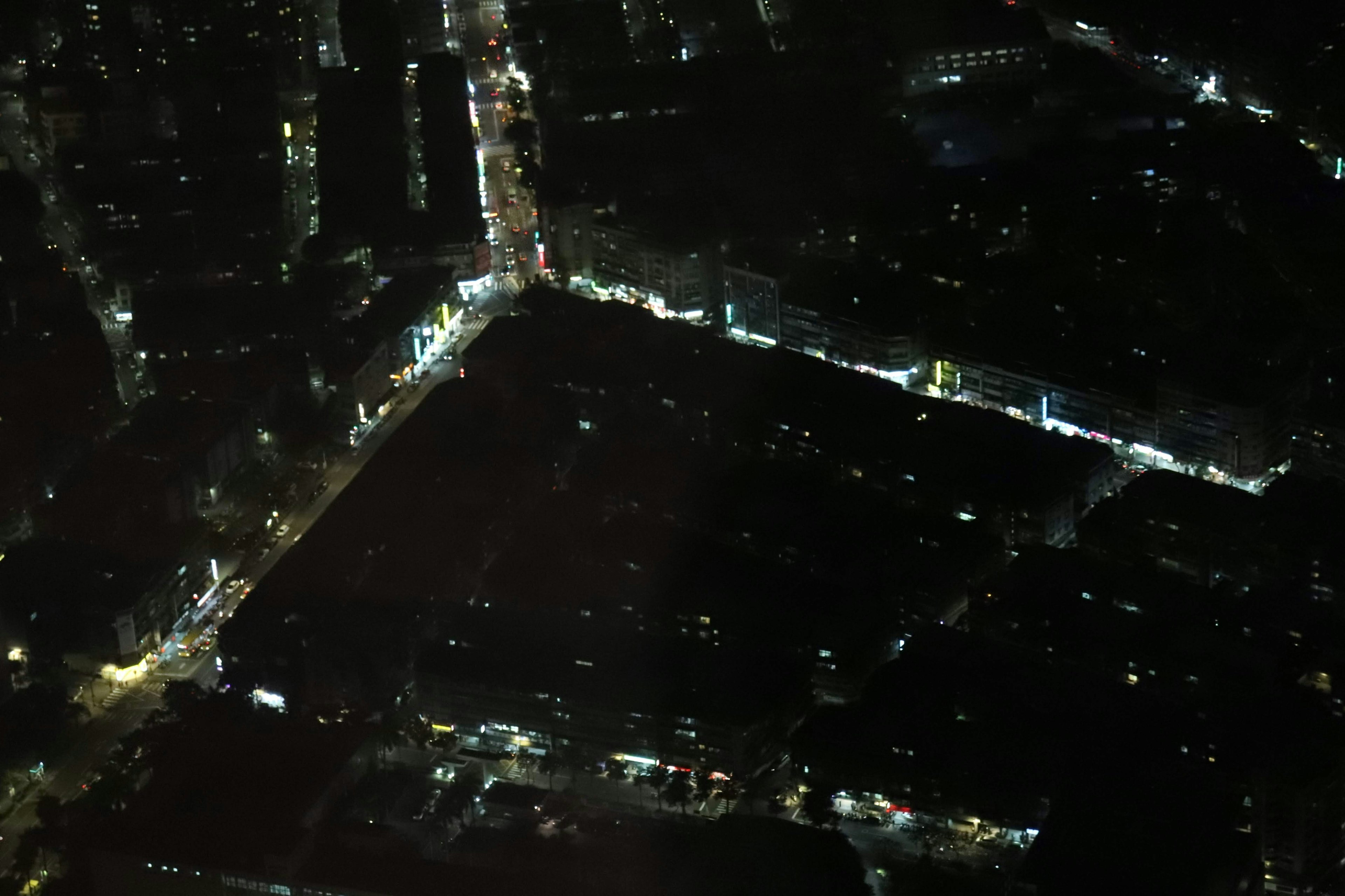 Aerial view of a city at night dimly lit areas with scattered streetlights