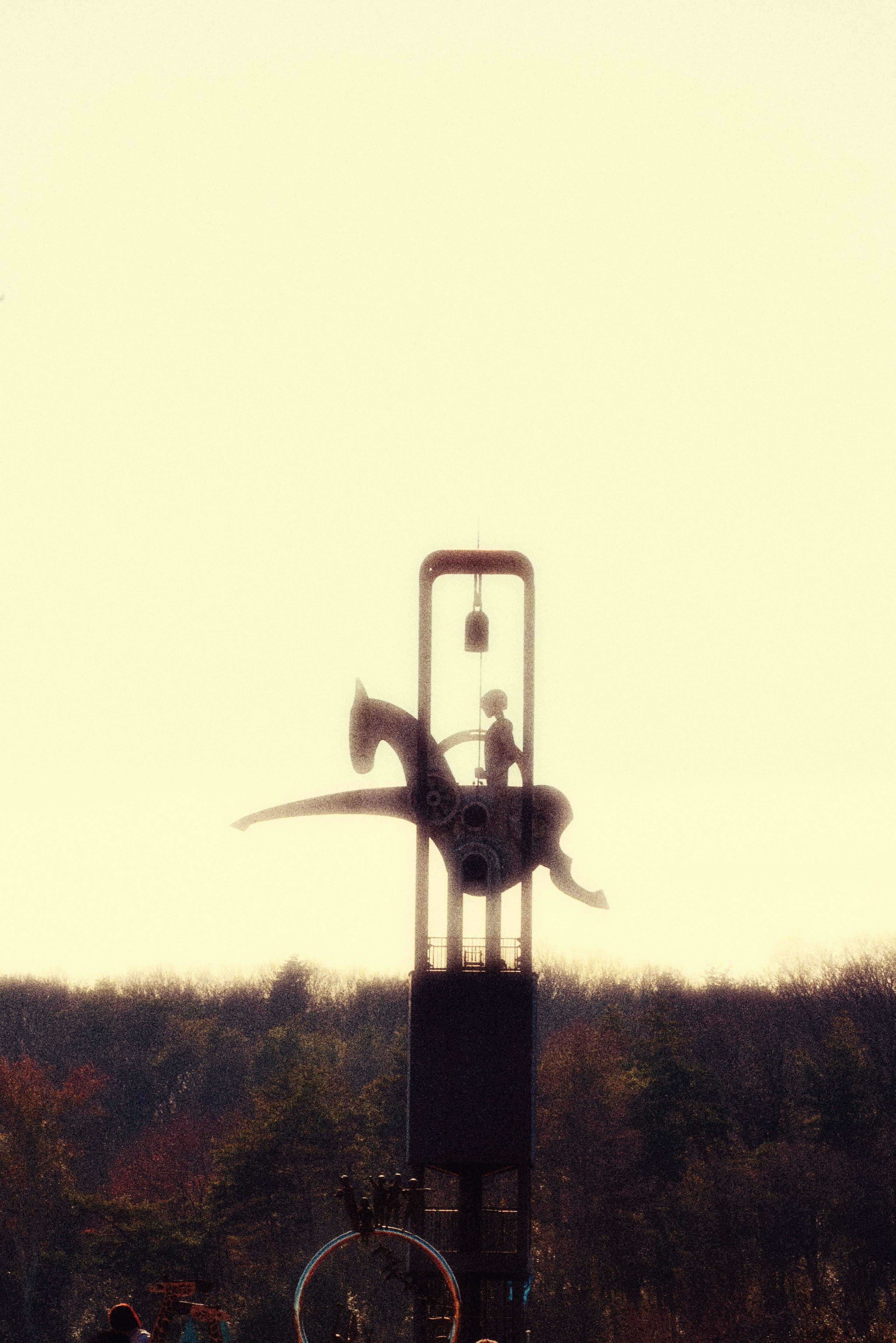 Silhouette of a person on a horse atop a tall structure