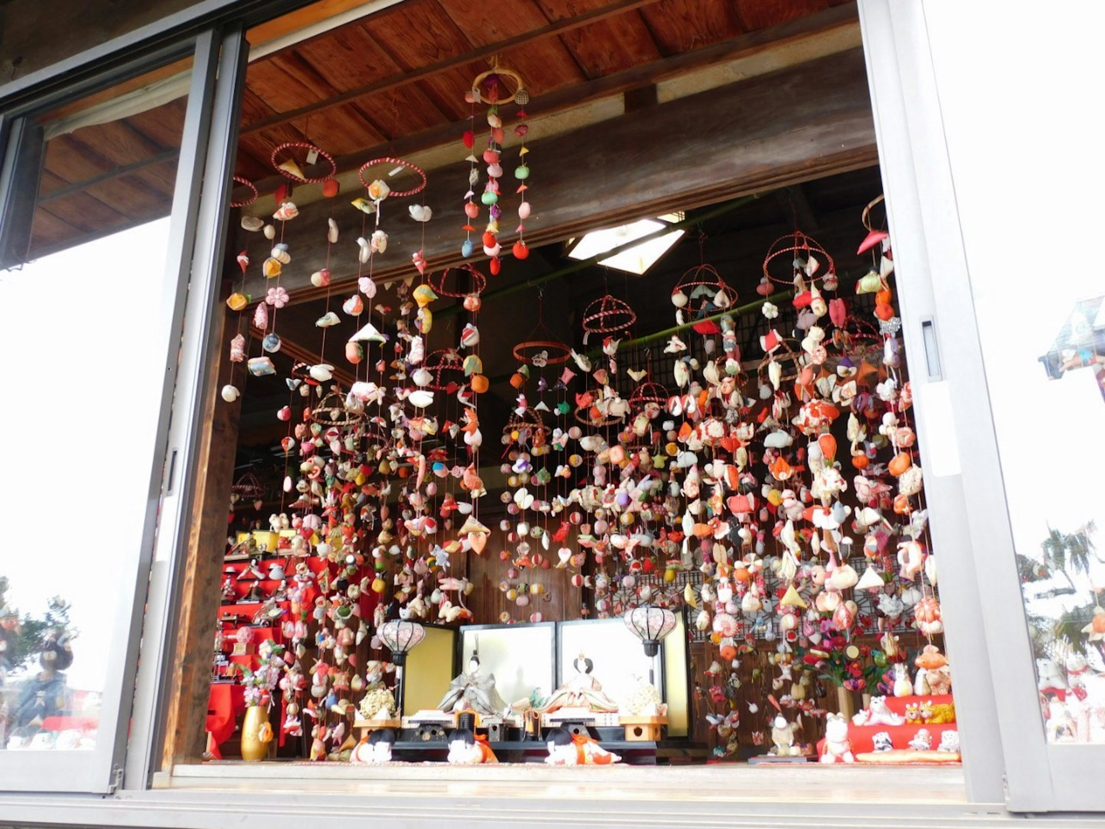 Colorful hanging decorations and traditional items displayed in a window