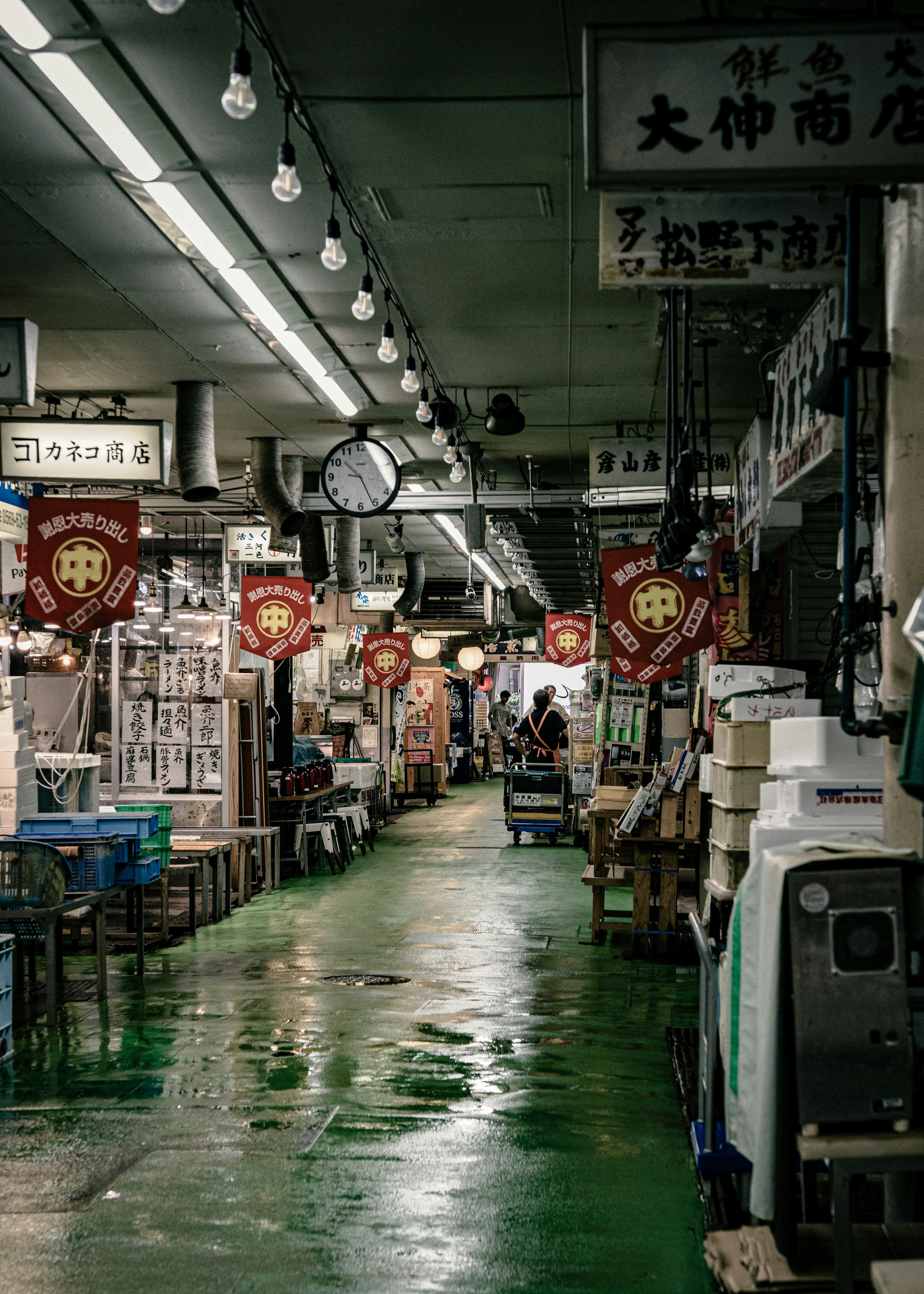 Dimly lit market aisle with shops and red lanterns