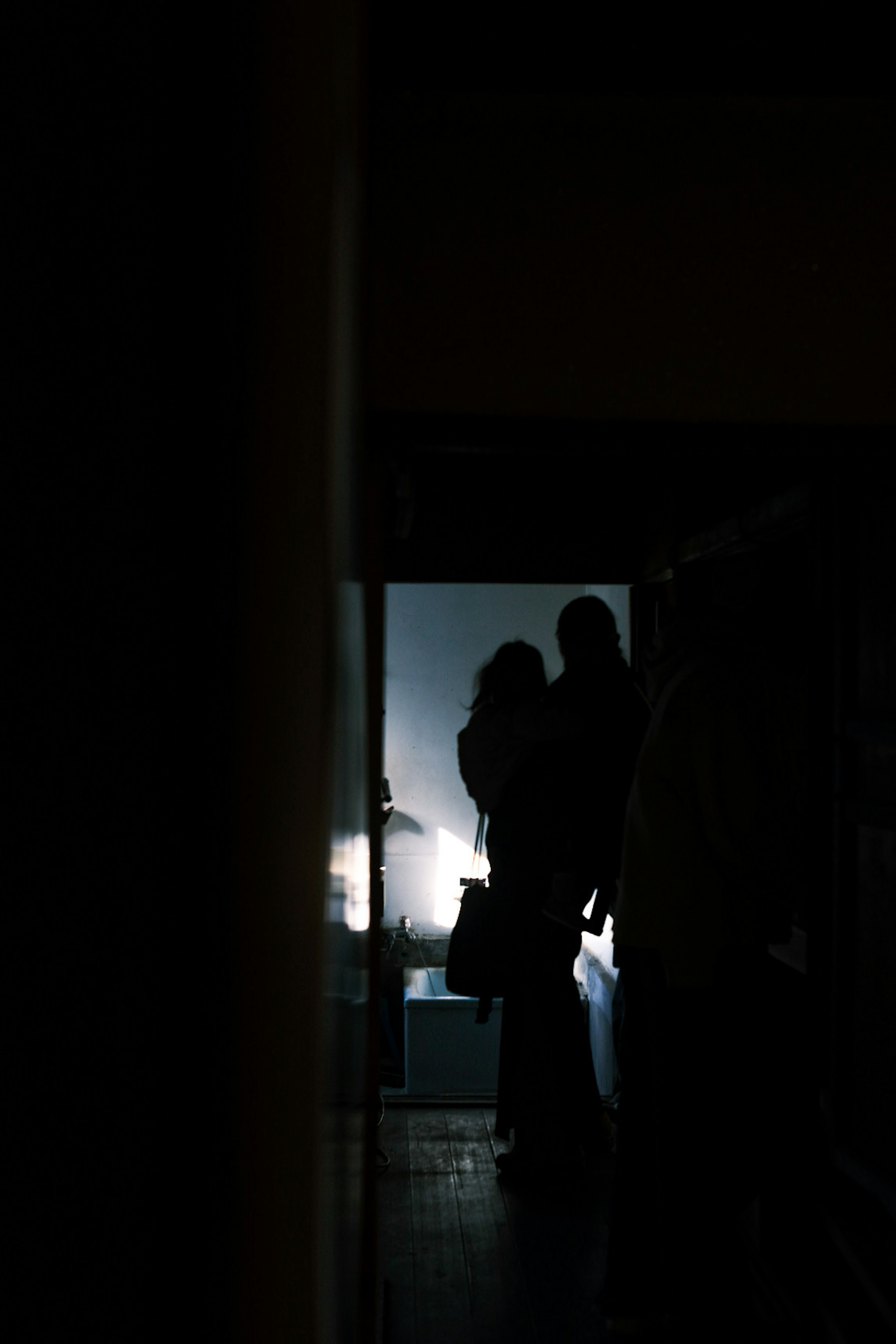 Silhouette of two people embracing in a dark room