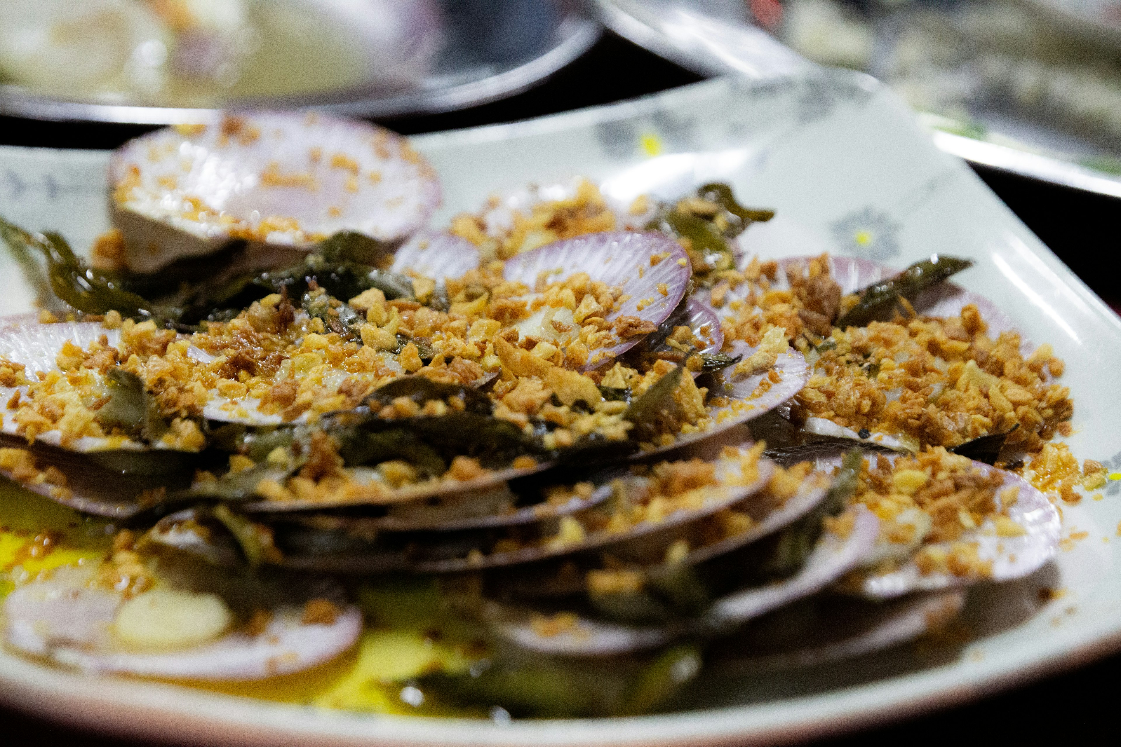 Une assiette de palourdes grillées garnies d'herbes et d'assaisonnement croustillant