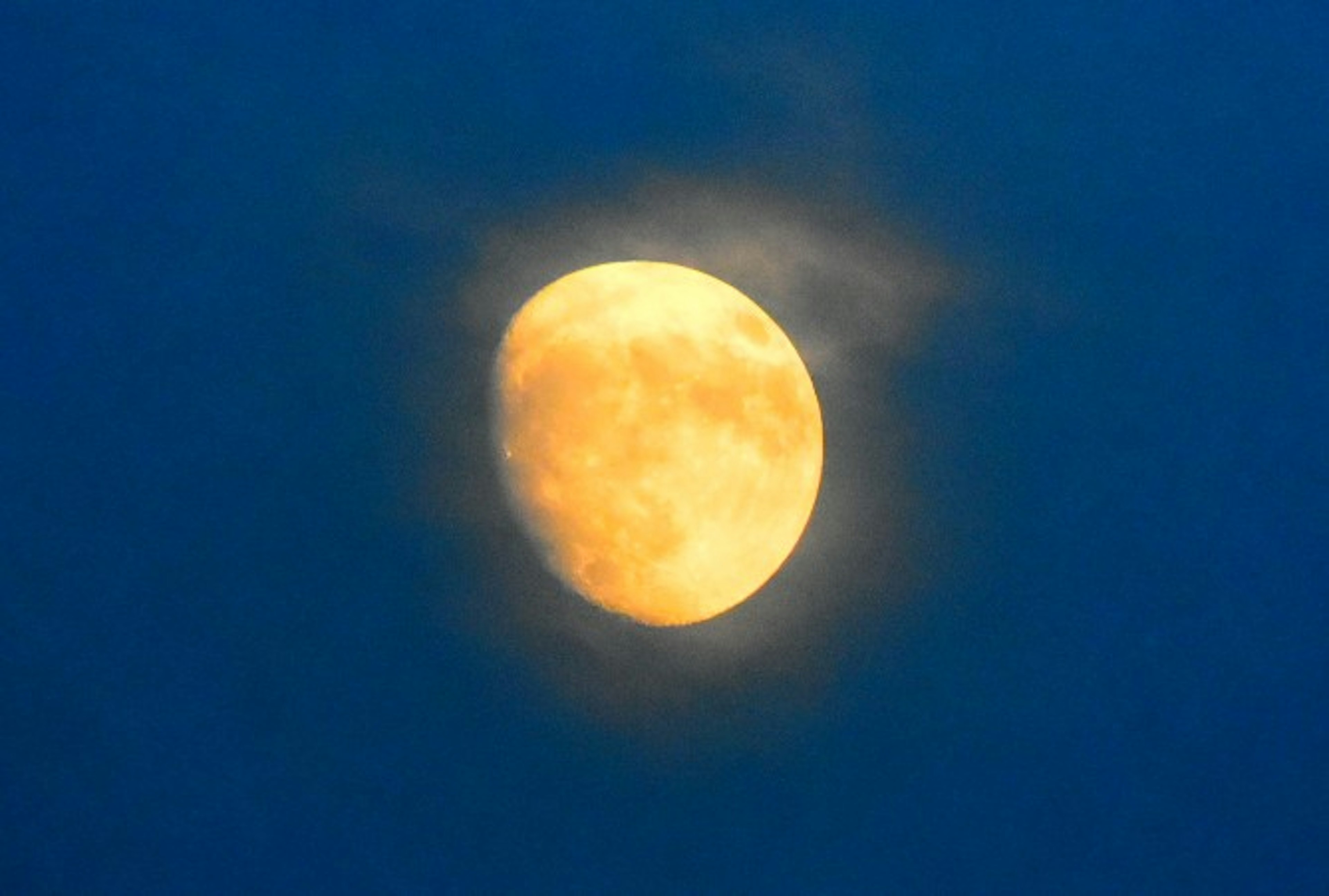 Eine Halbmond, der gegen einen blauen Himmel leuchtet