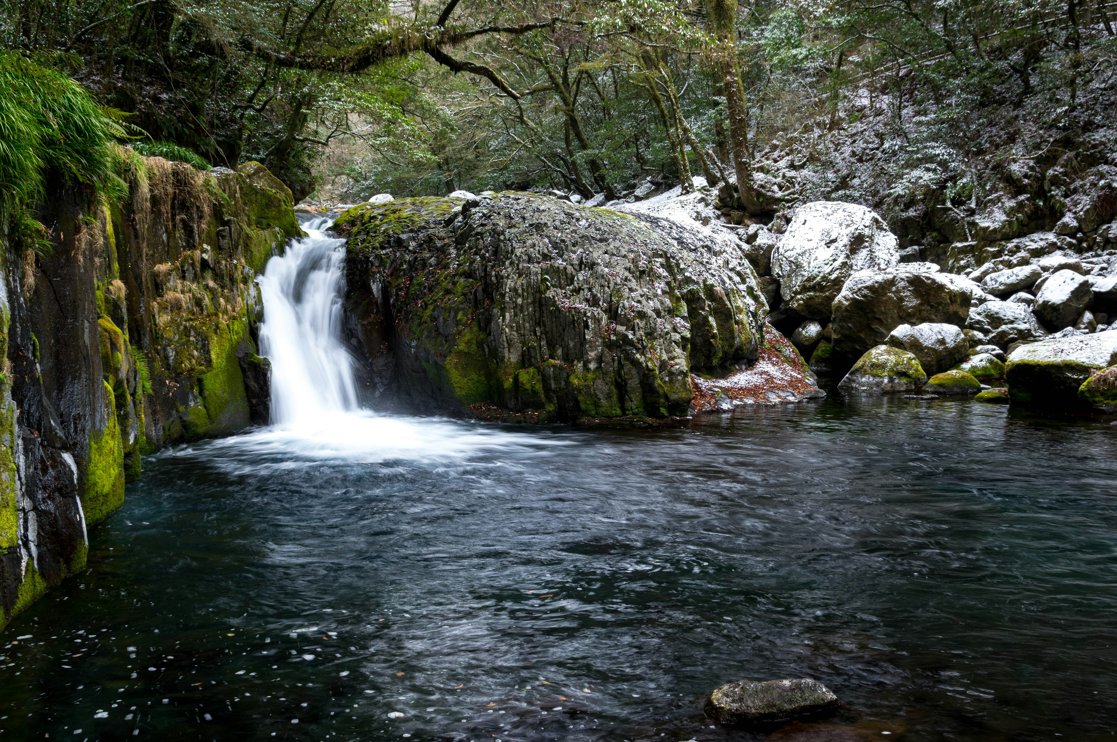 Cascade sereine tombant sur des rochers couverts de mousse