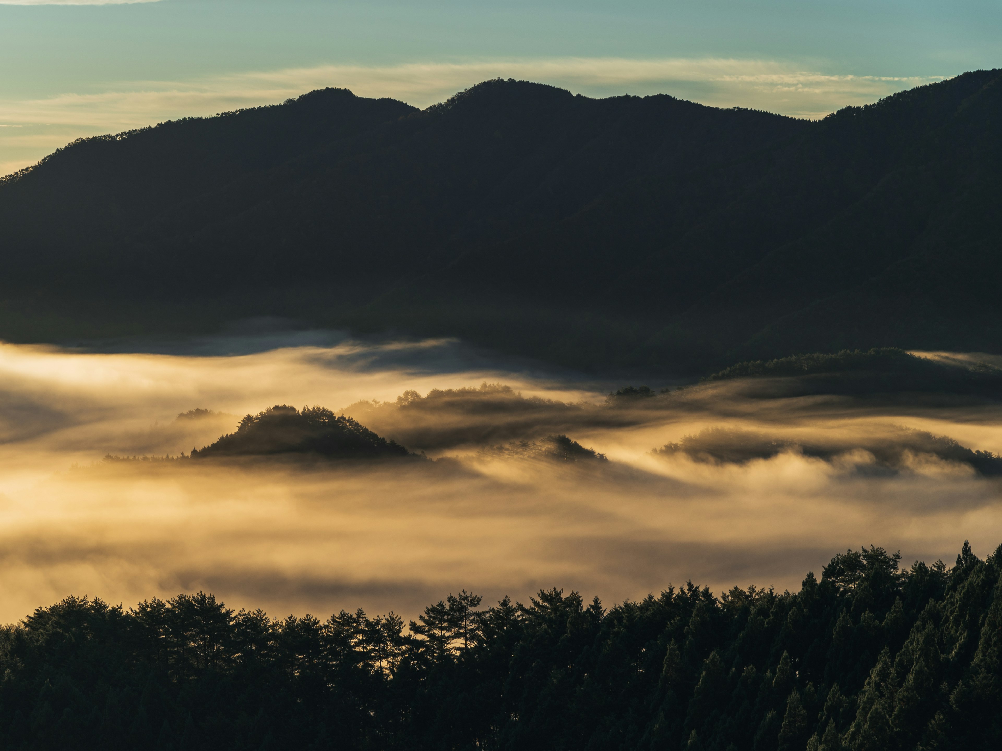 霧に包まれた山々の風景と青空