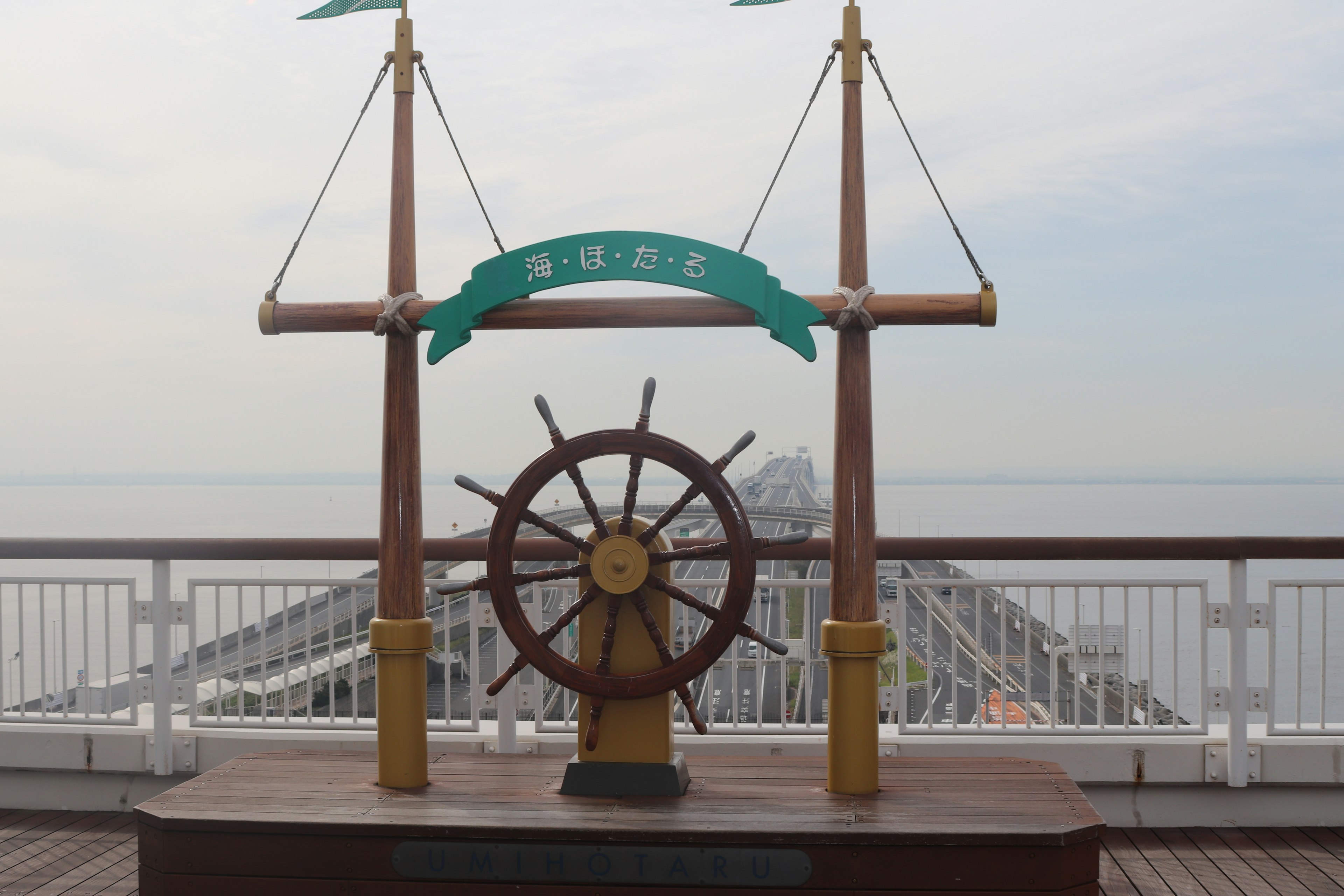 Vista de la cubierta con un timón de barco y un cartel