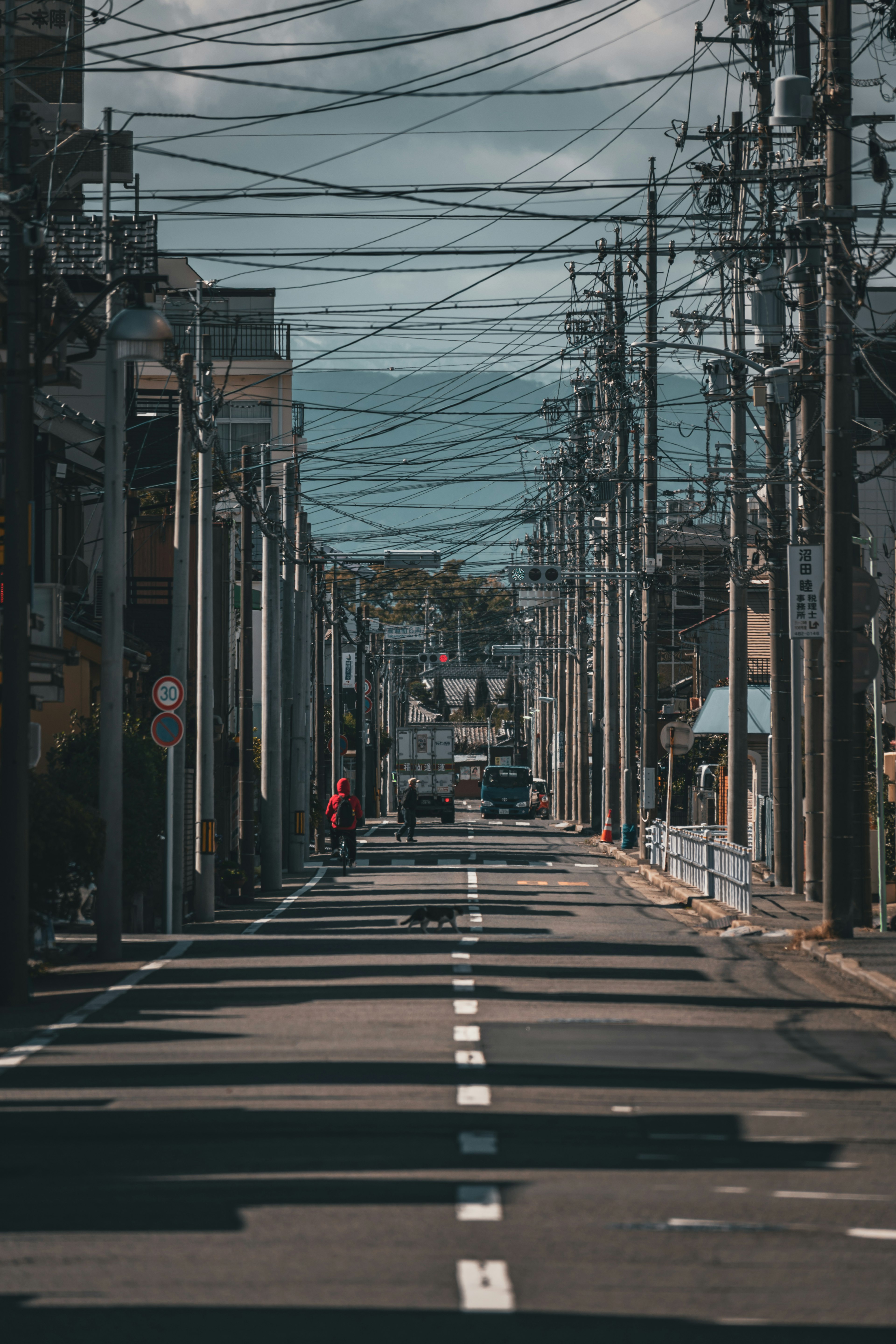 Scène de rue calme avec des poteaux électriques et des lignes électriques