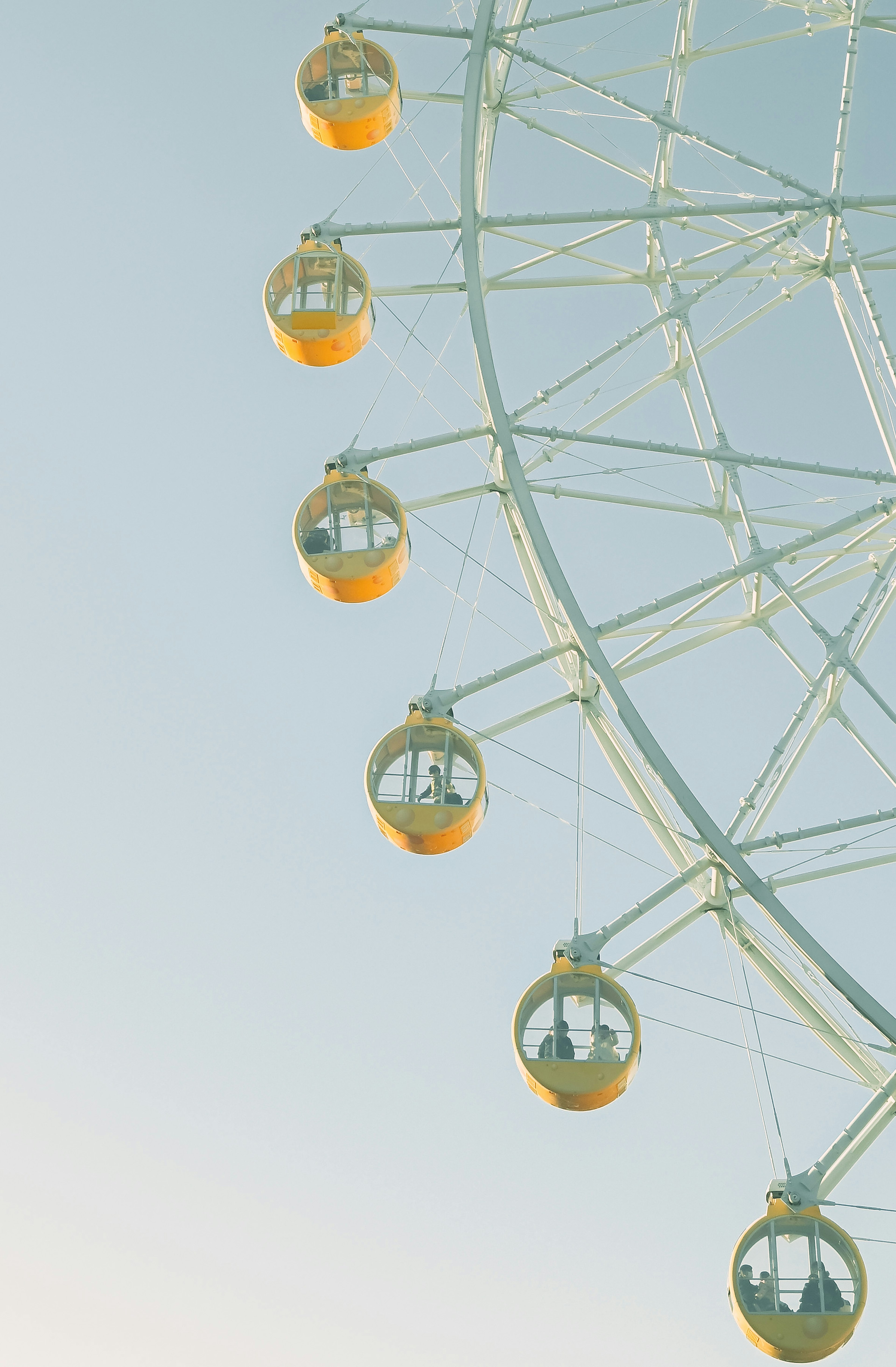 Close-up of a Ferris wheel gondolas against a blue sky