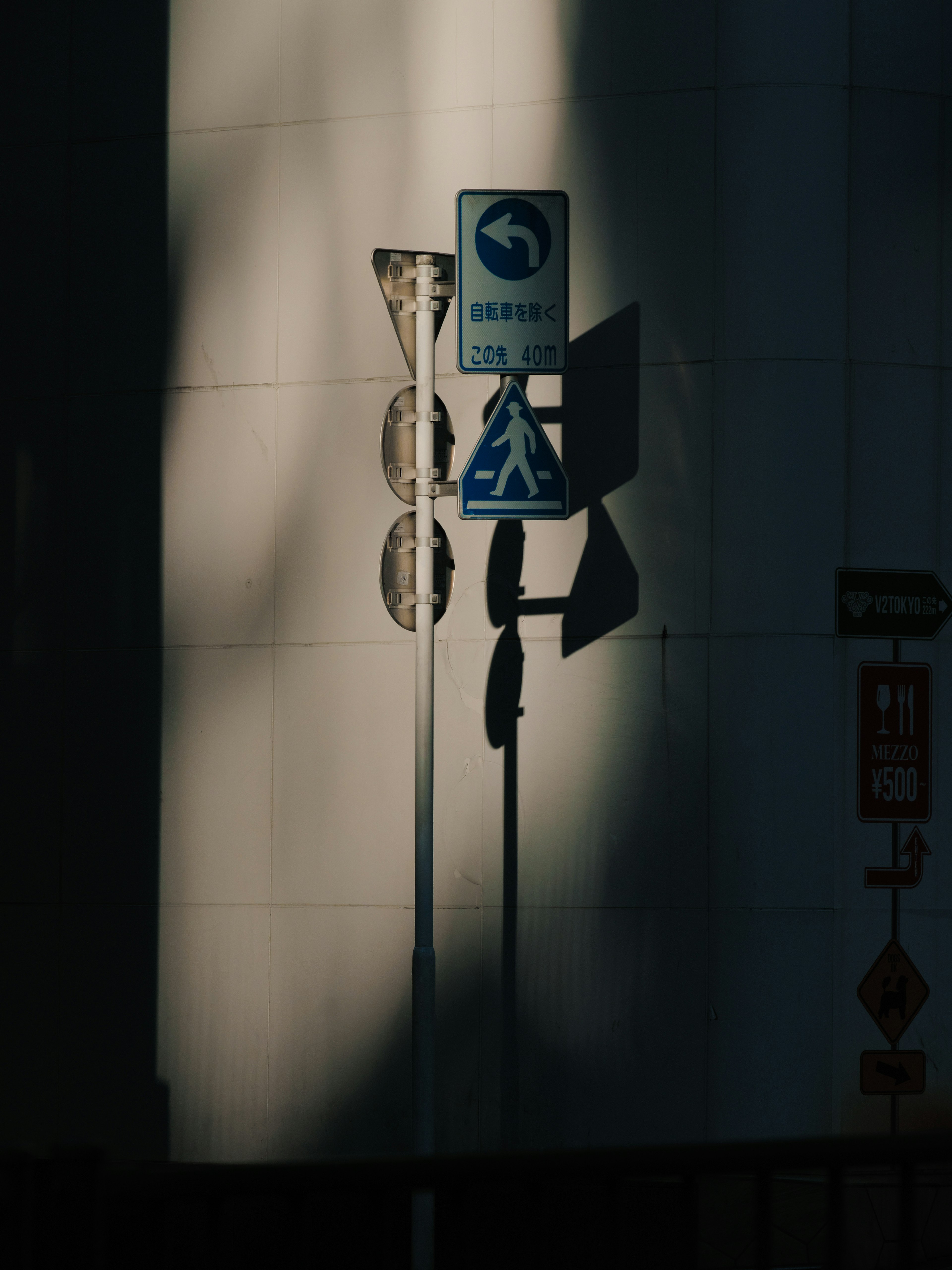 Panneaux de signalisation projetant des ombres sur un mur