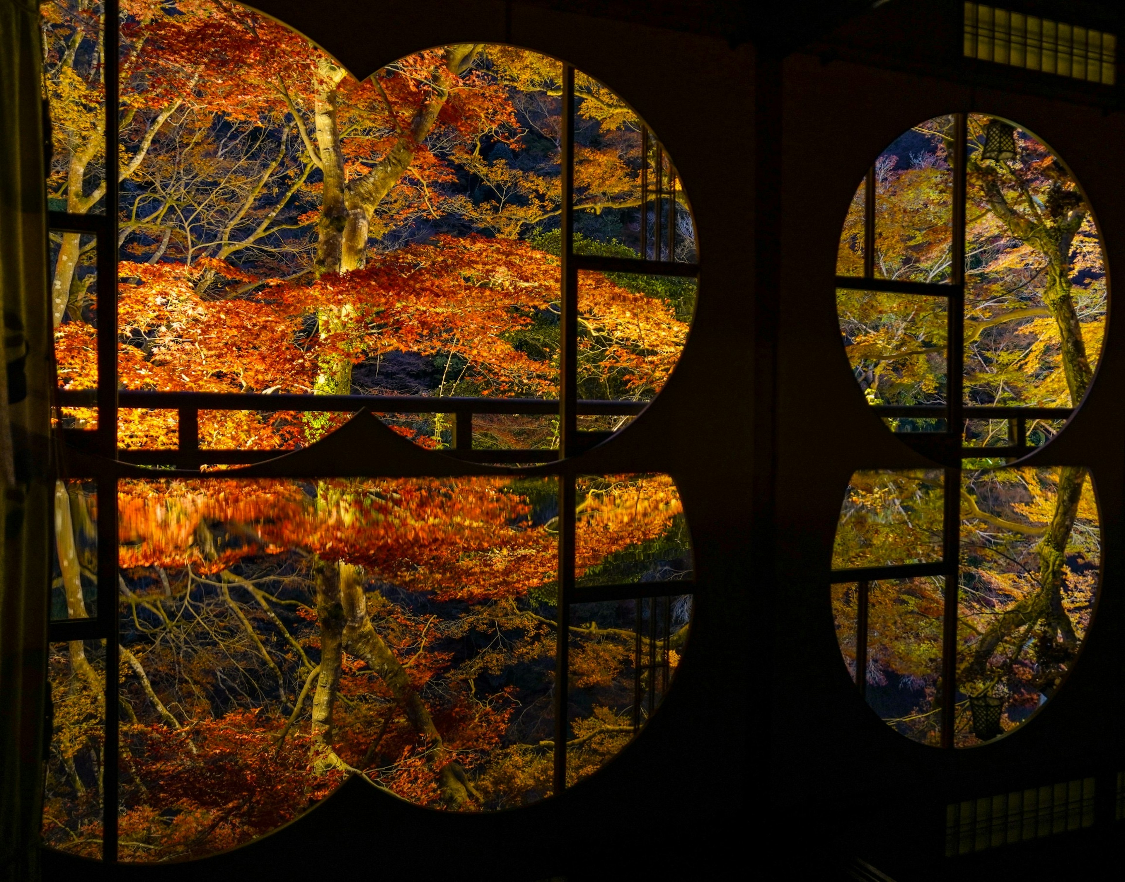 Kreisförmige Fenster, die das Herbstlaub im Wasser reflektieren