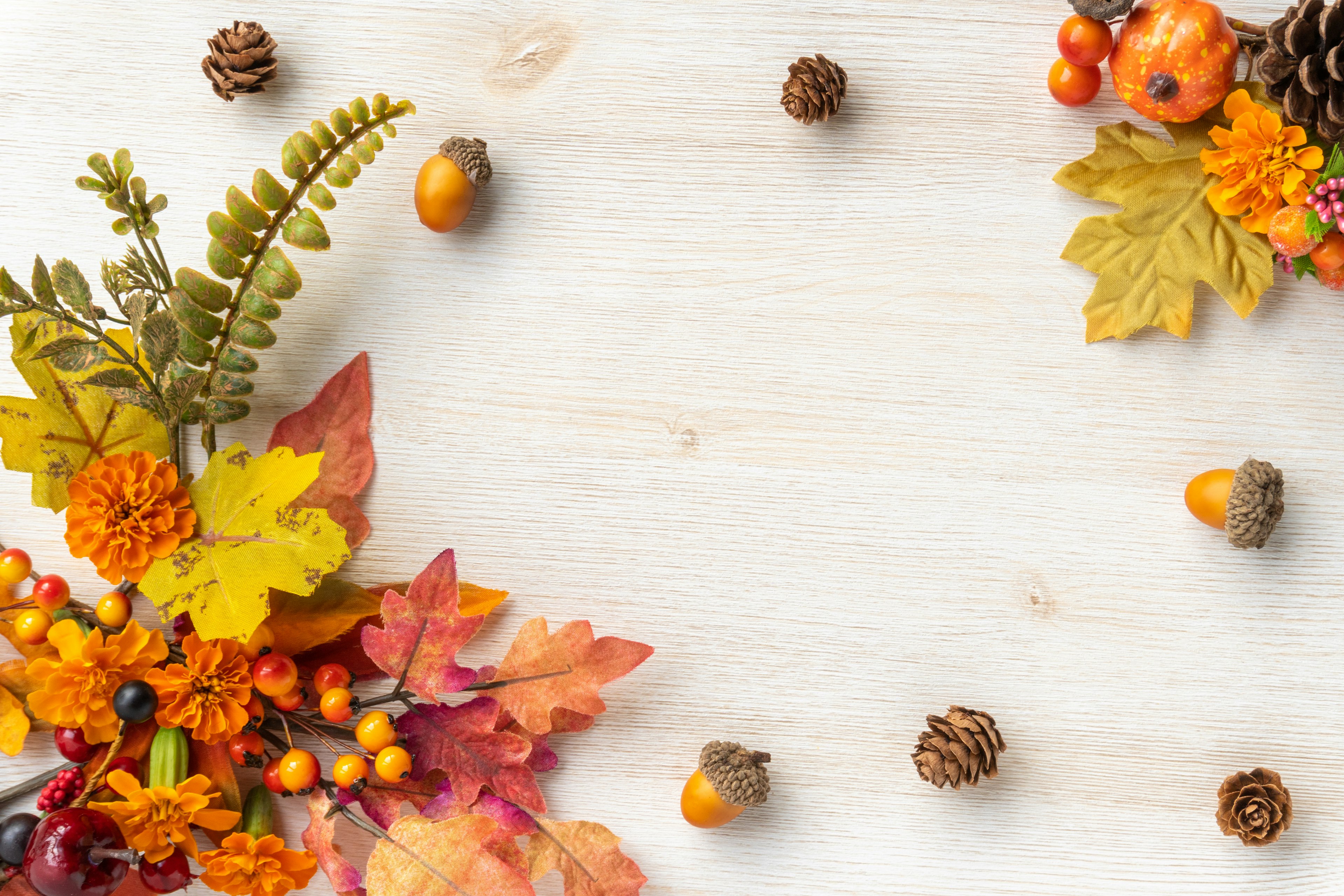 Colorful autumn leaves and pine cones arranged on a wooden table creating a seasonal decoration