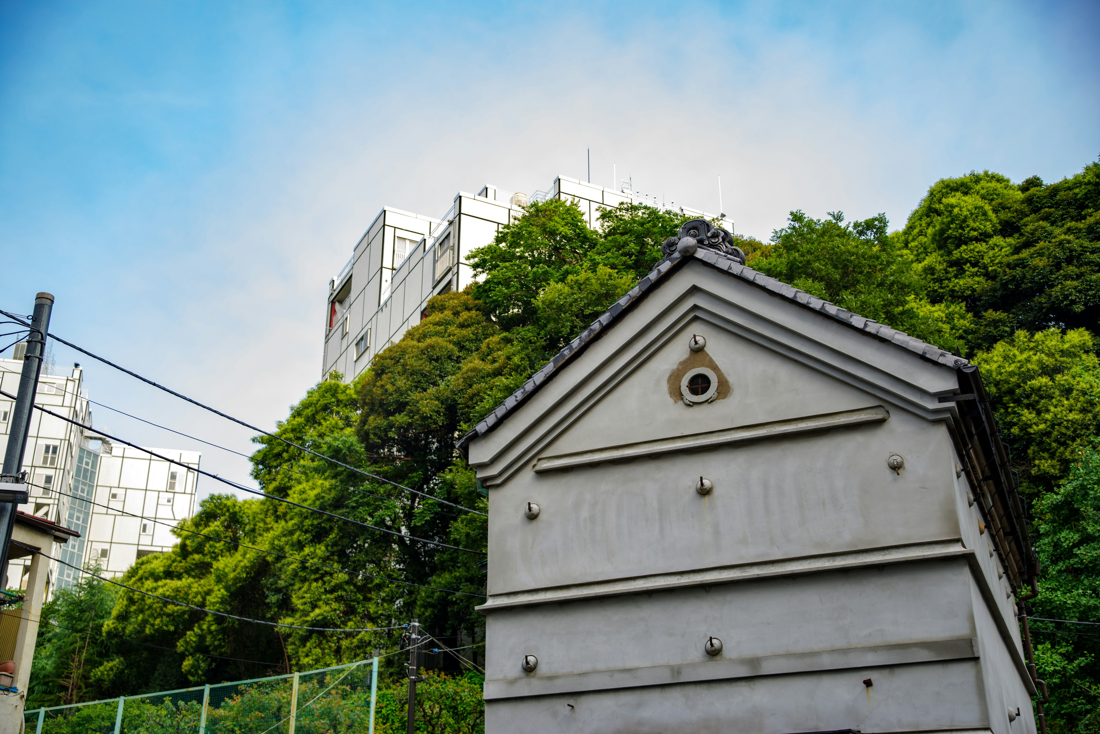 緑豊かな丘の側にある特徴的な建物と青空