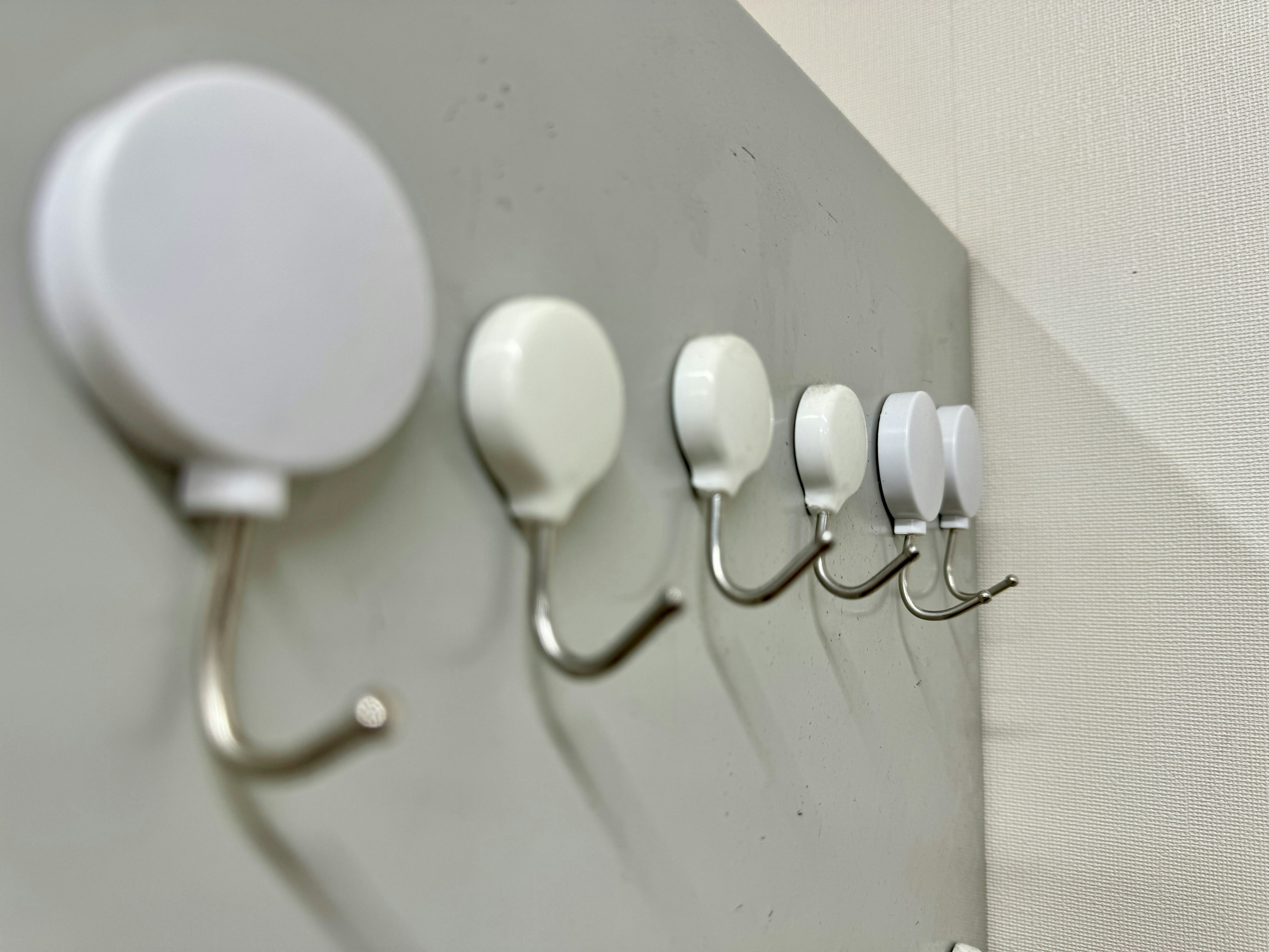 Row of white hooks on a wall