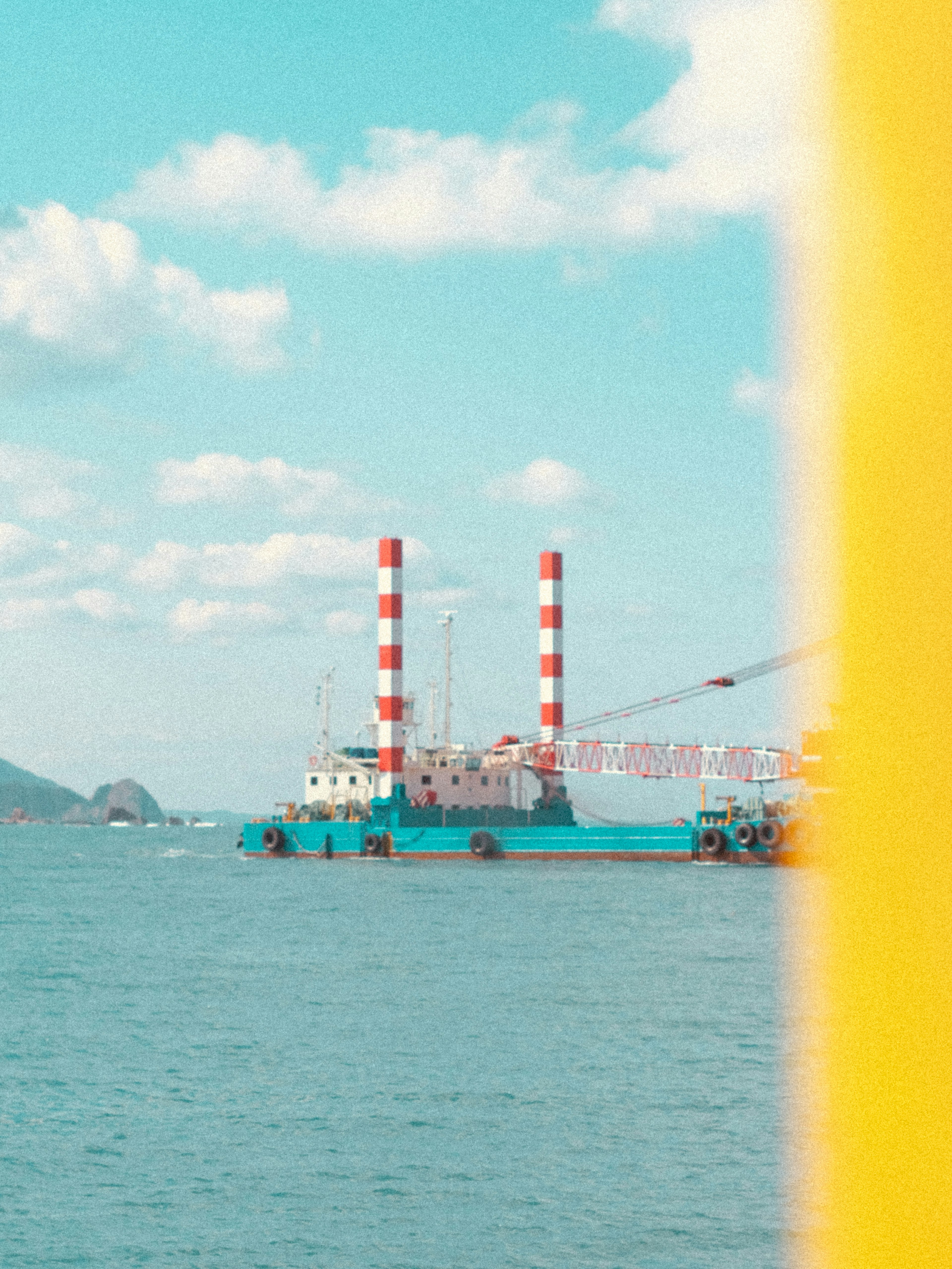 A ship with red and white smokestacks anchored in a blue sea