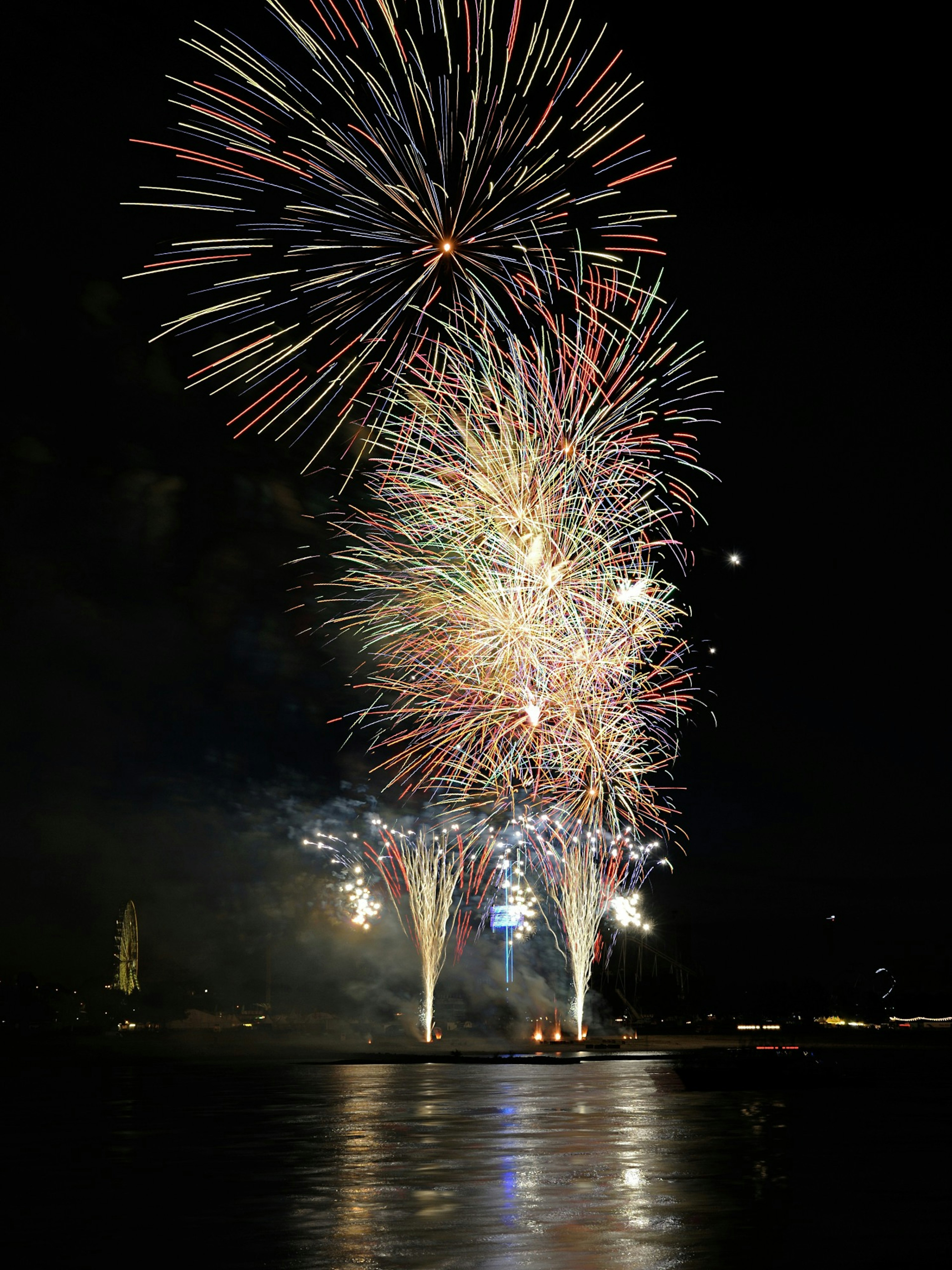 Colorful fireworks display lighting up the night sky over water