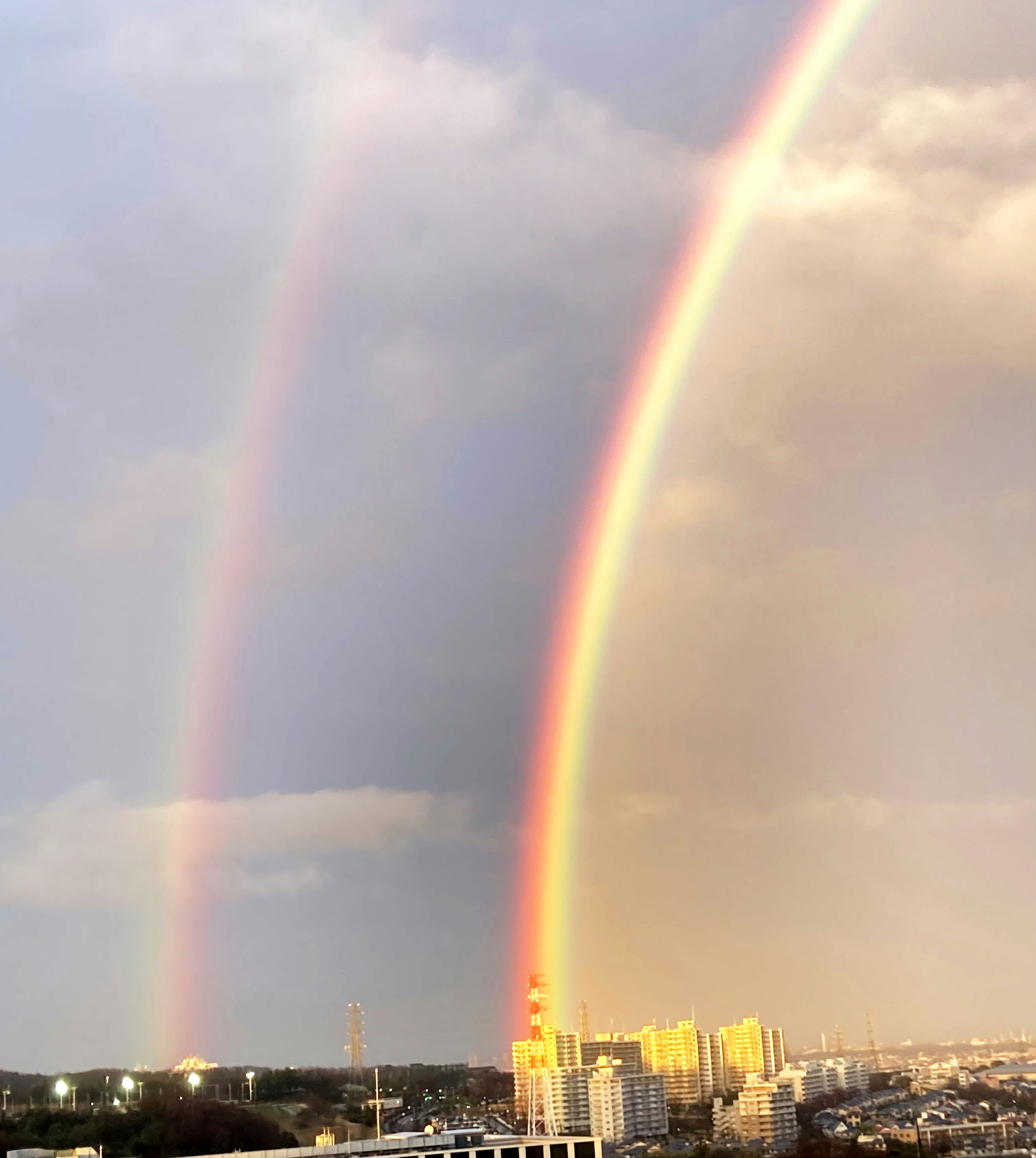 Double rainbow over a city skyline