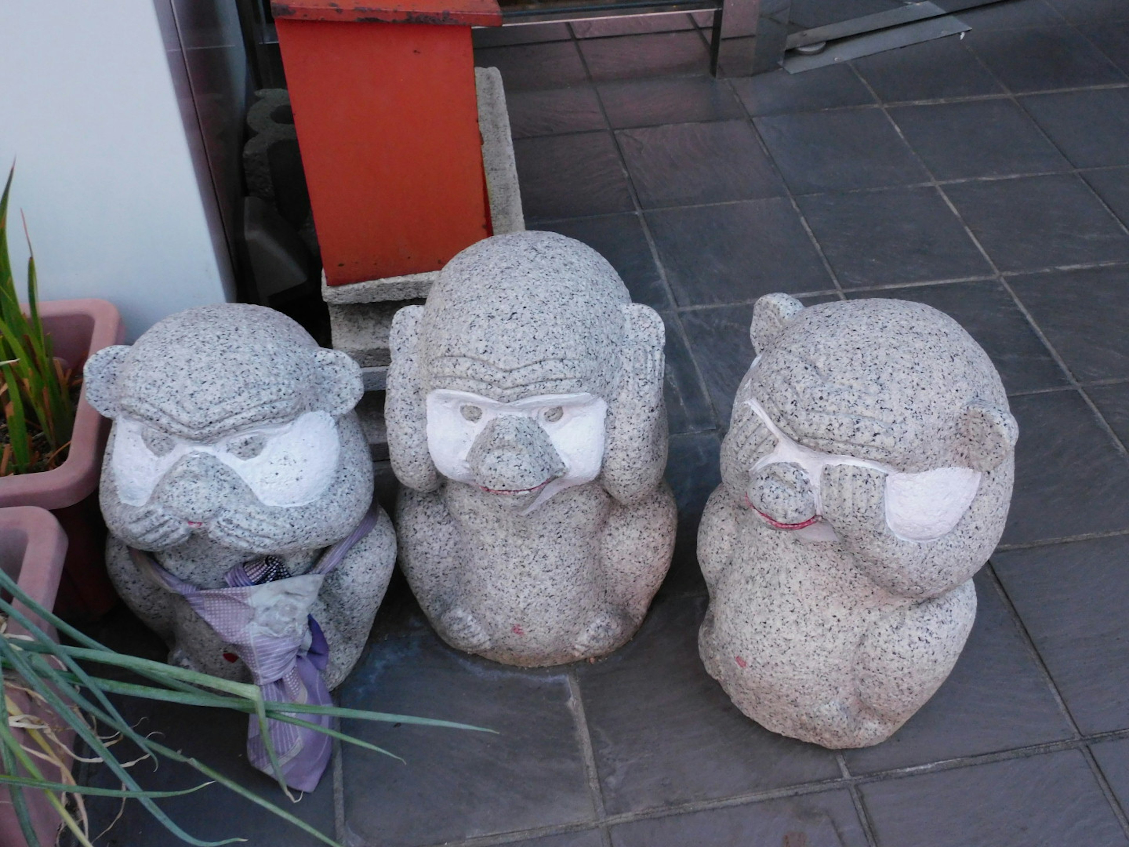 Three stone statues lined up with different expressions