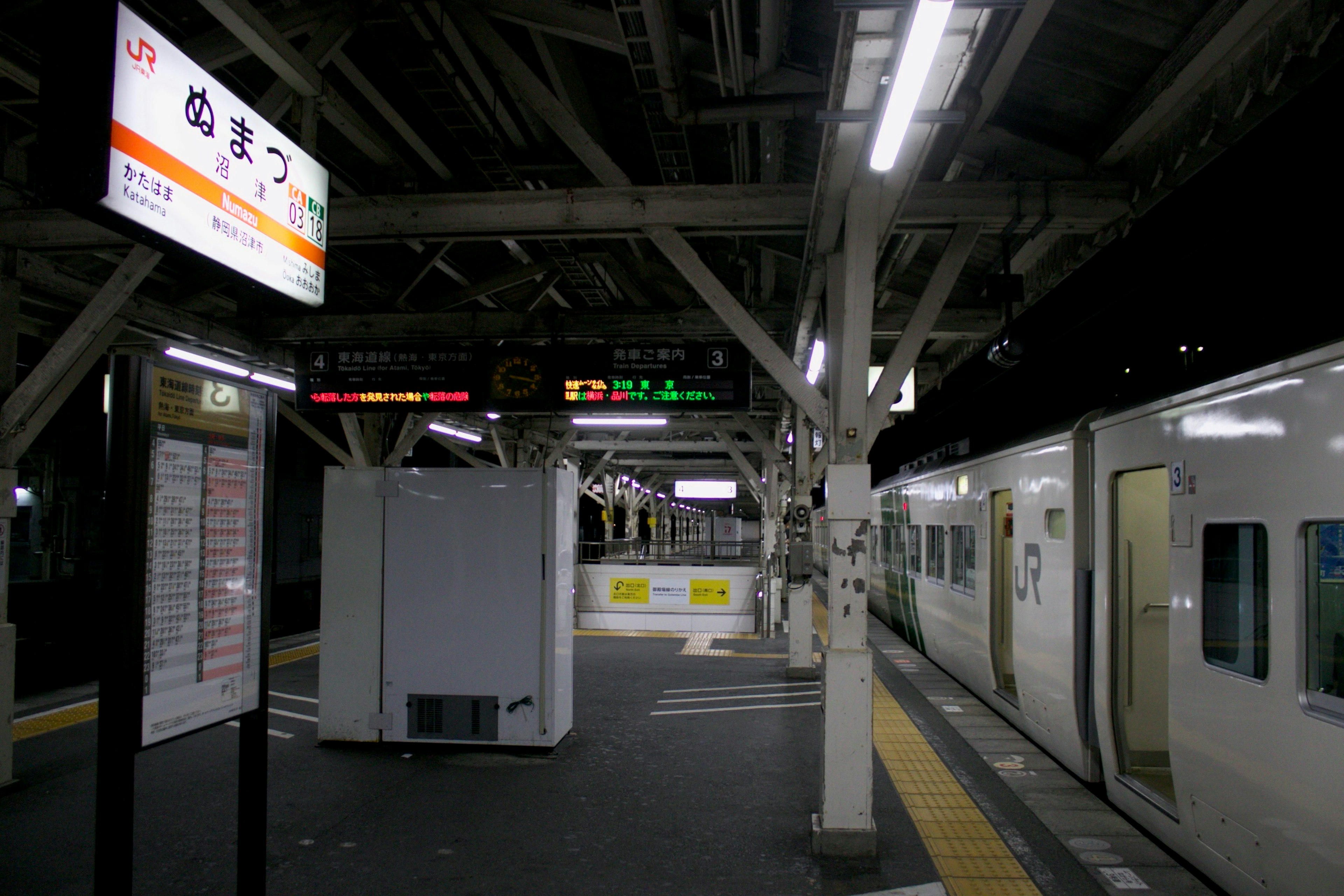 暗い駅での電車と標識がある風景