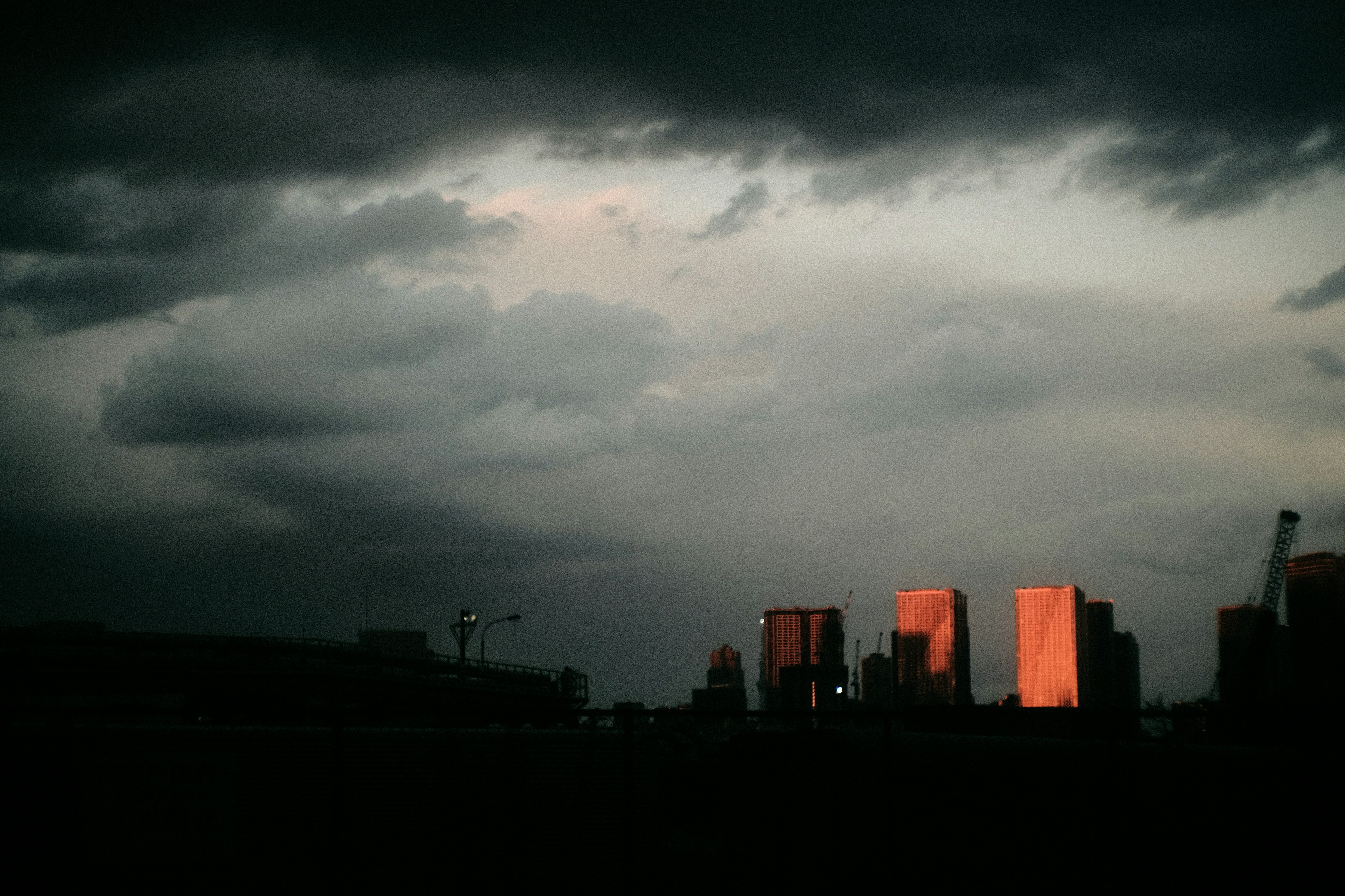 Silhouette of skyscrapers against dark clouds