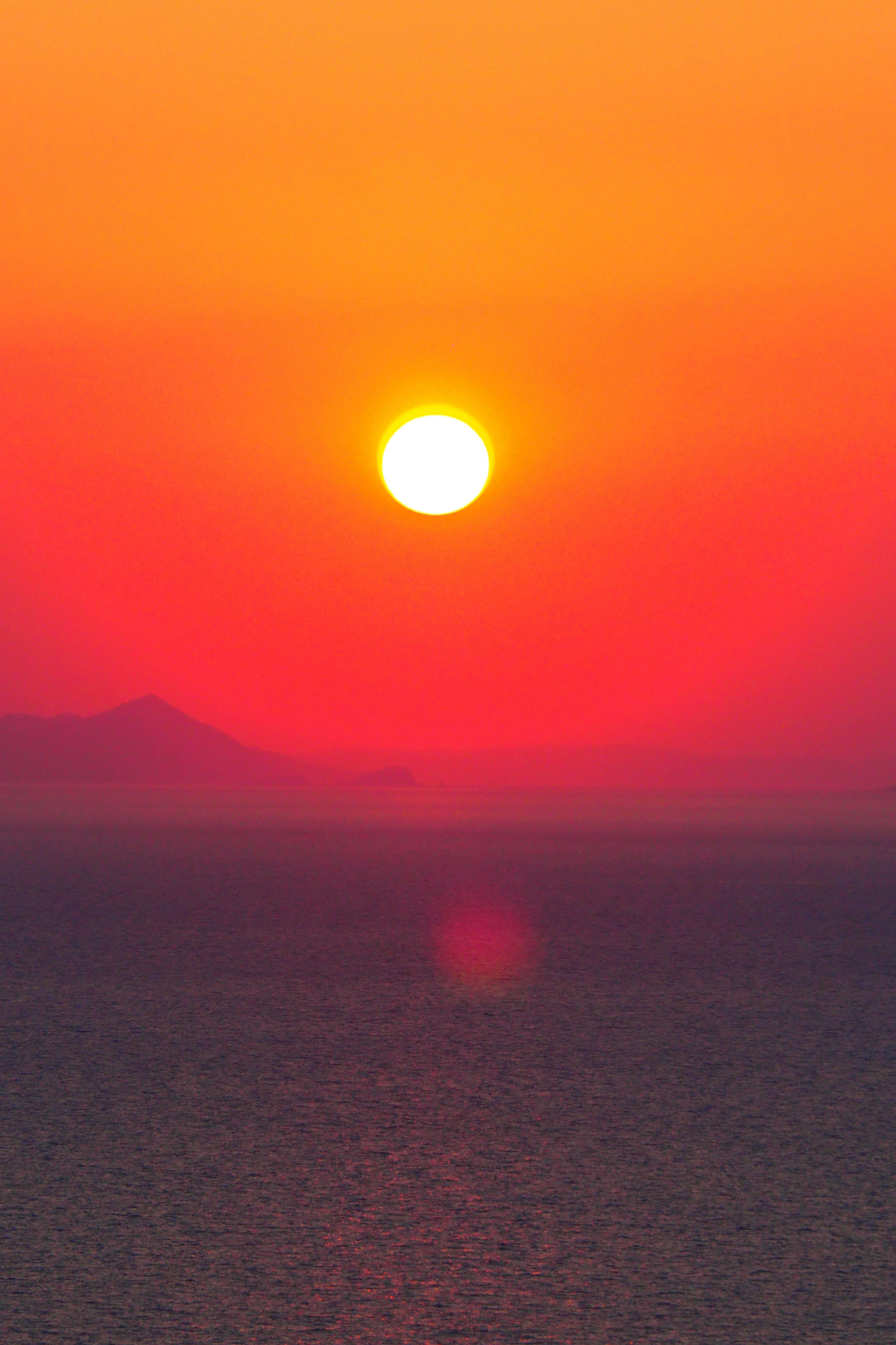 Beautiful sunset over the ocean vibrant red and orange gradient