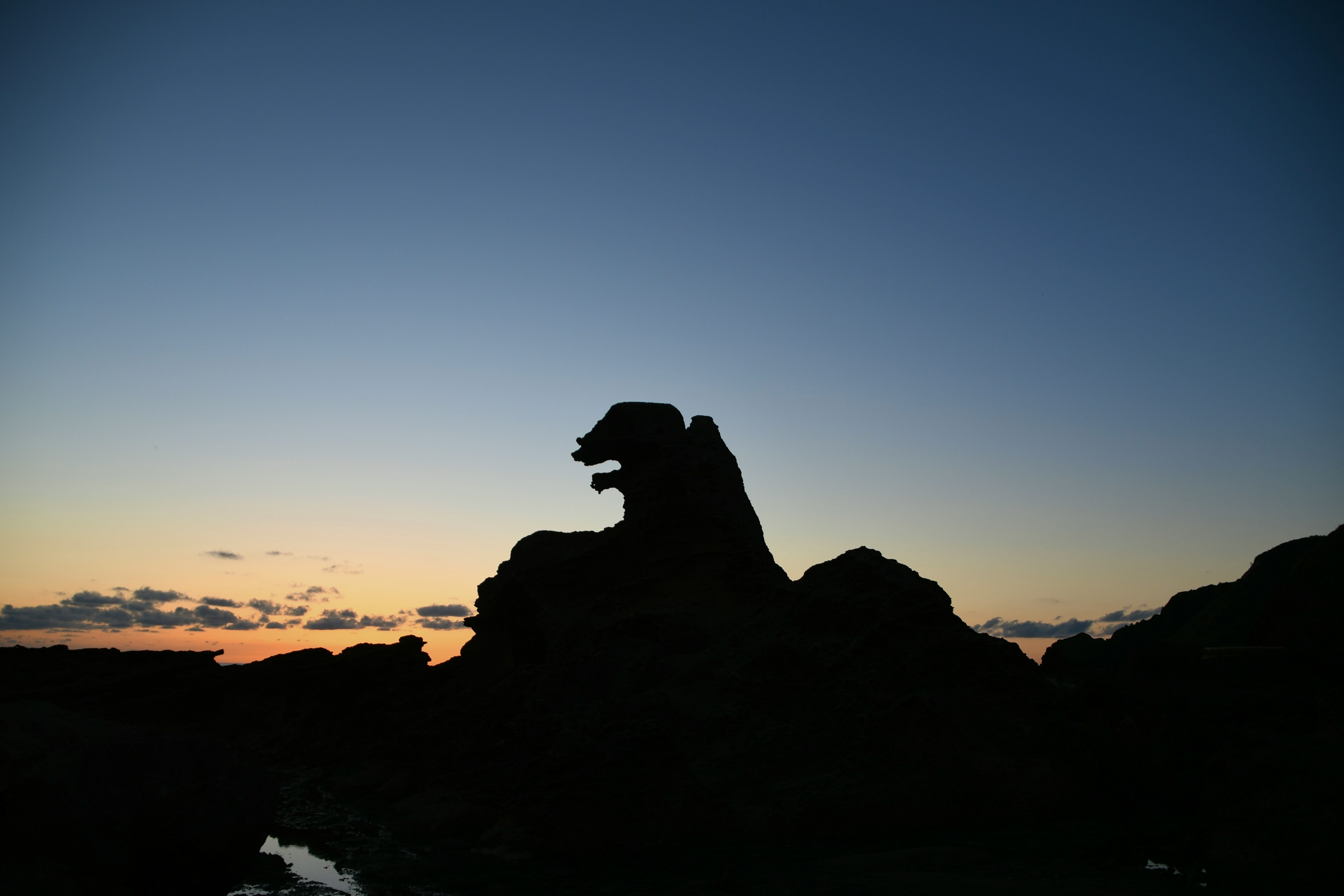 Silueta de una formación rocosa que parece un león al atardecer