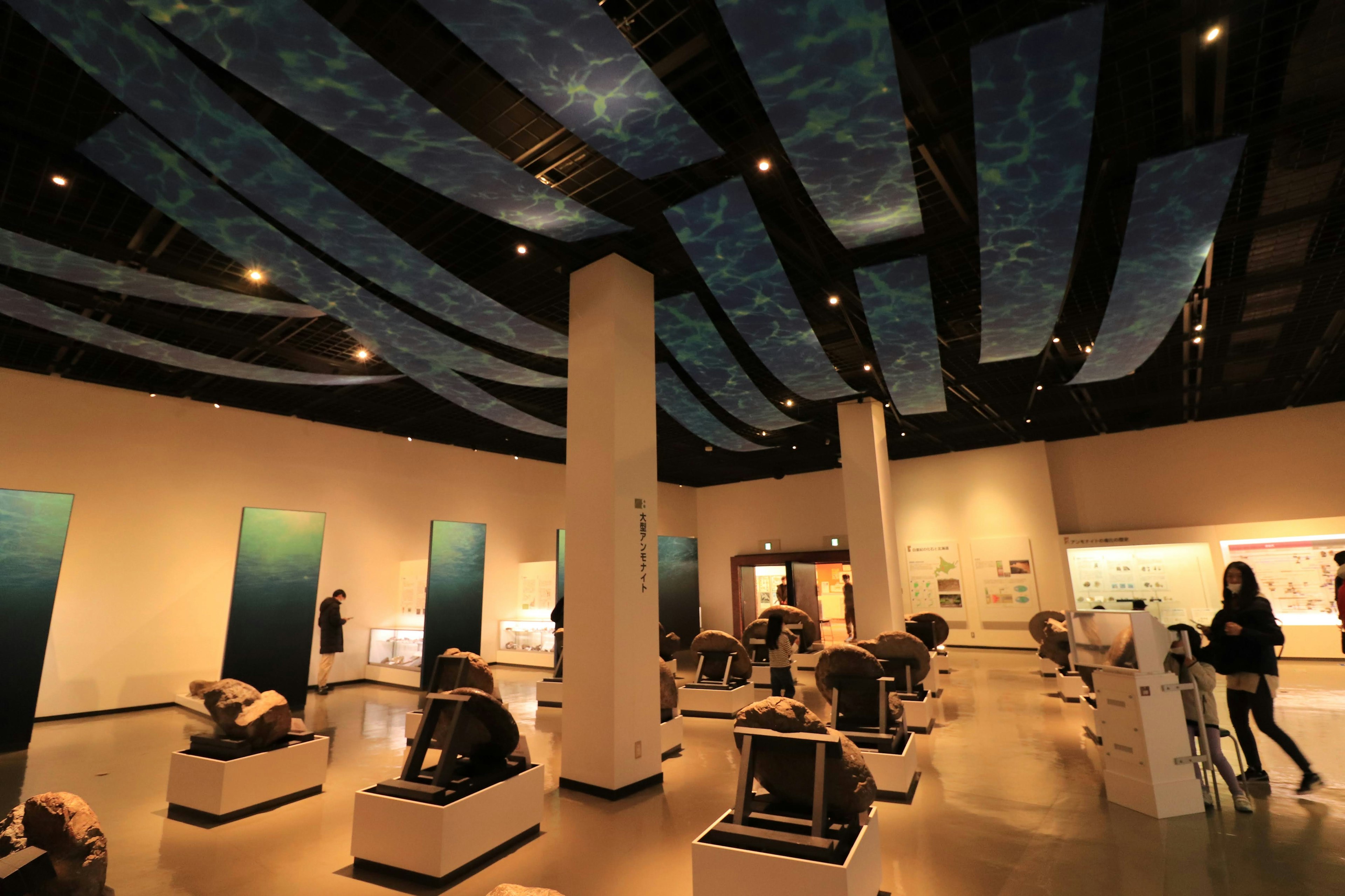 Interior museum seni dengan langit-langit biru dan patung yang dipamerkan