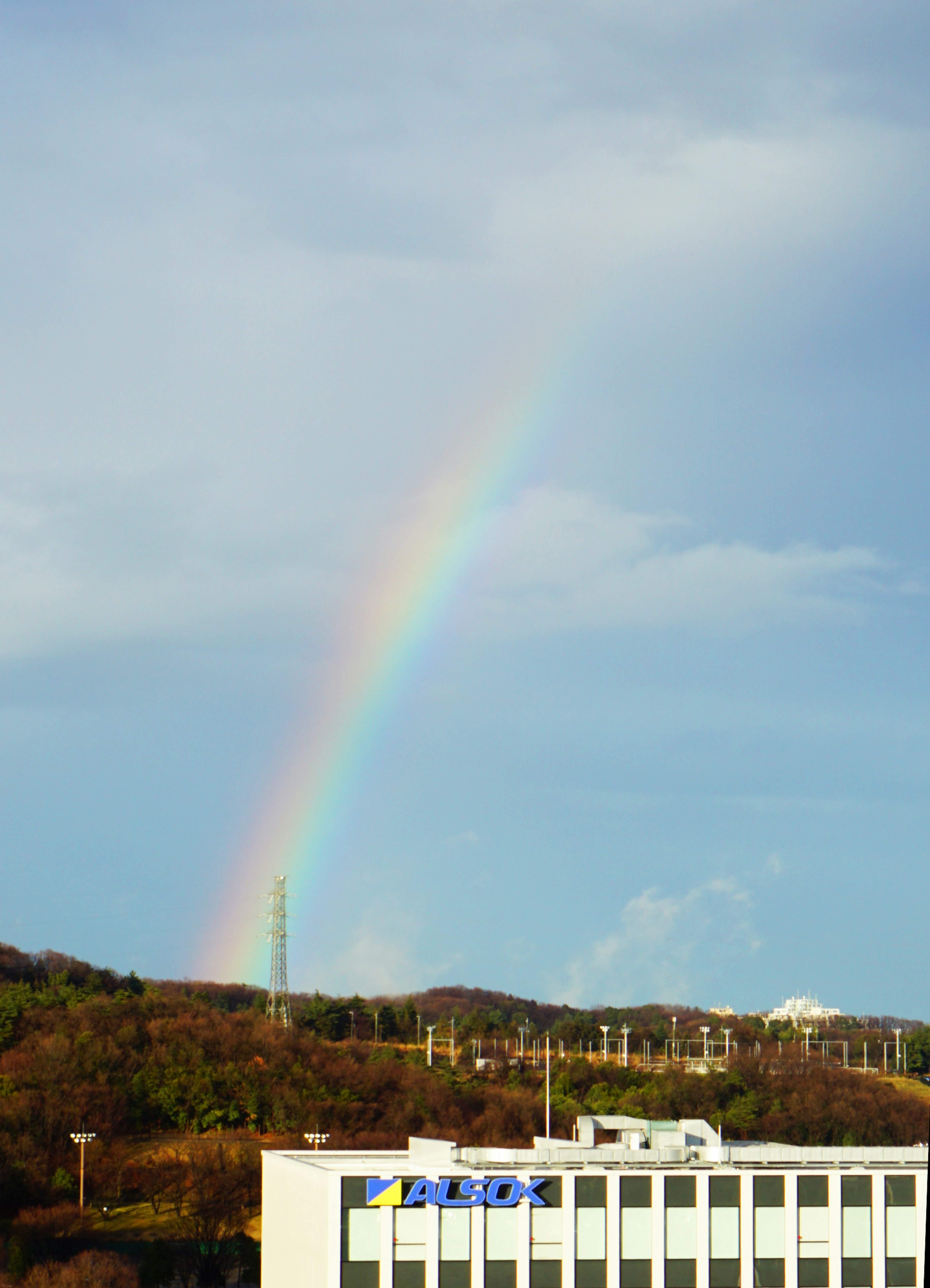 虹がかかる青空と緑の丘の風景