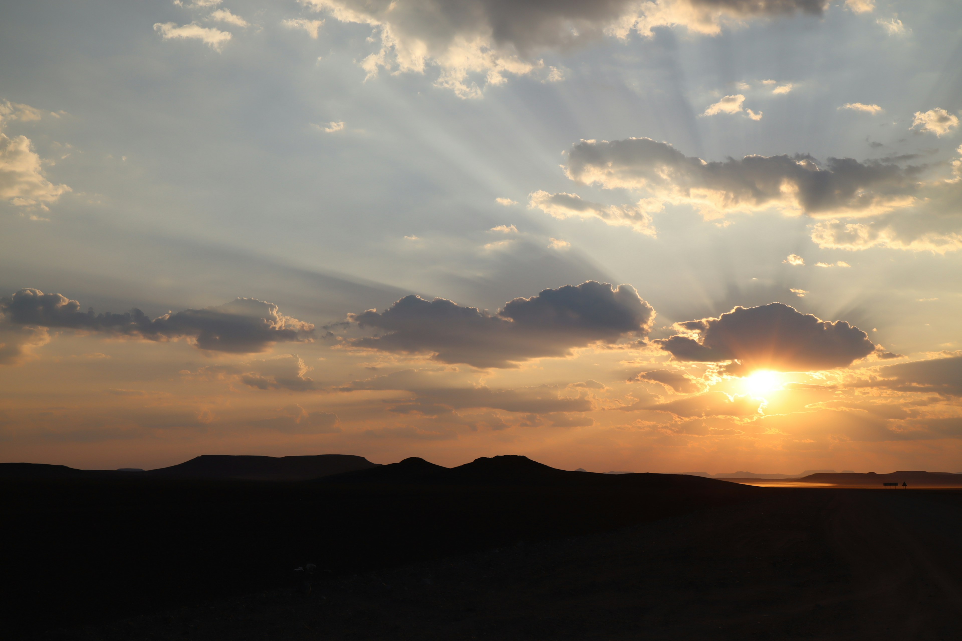 Schöner Sonnenuntergangshimmel mit Wolken und Silhouette