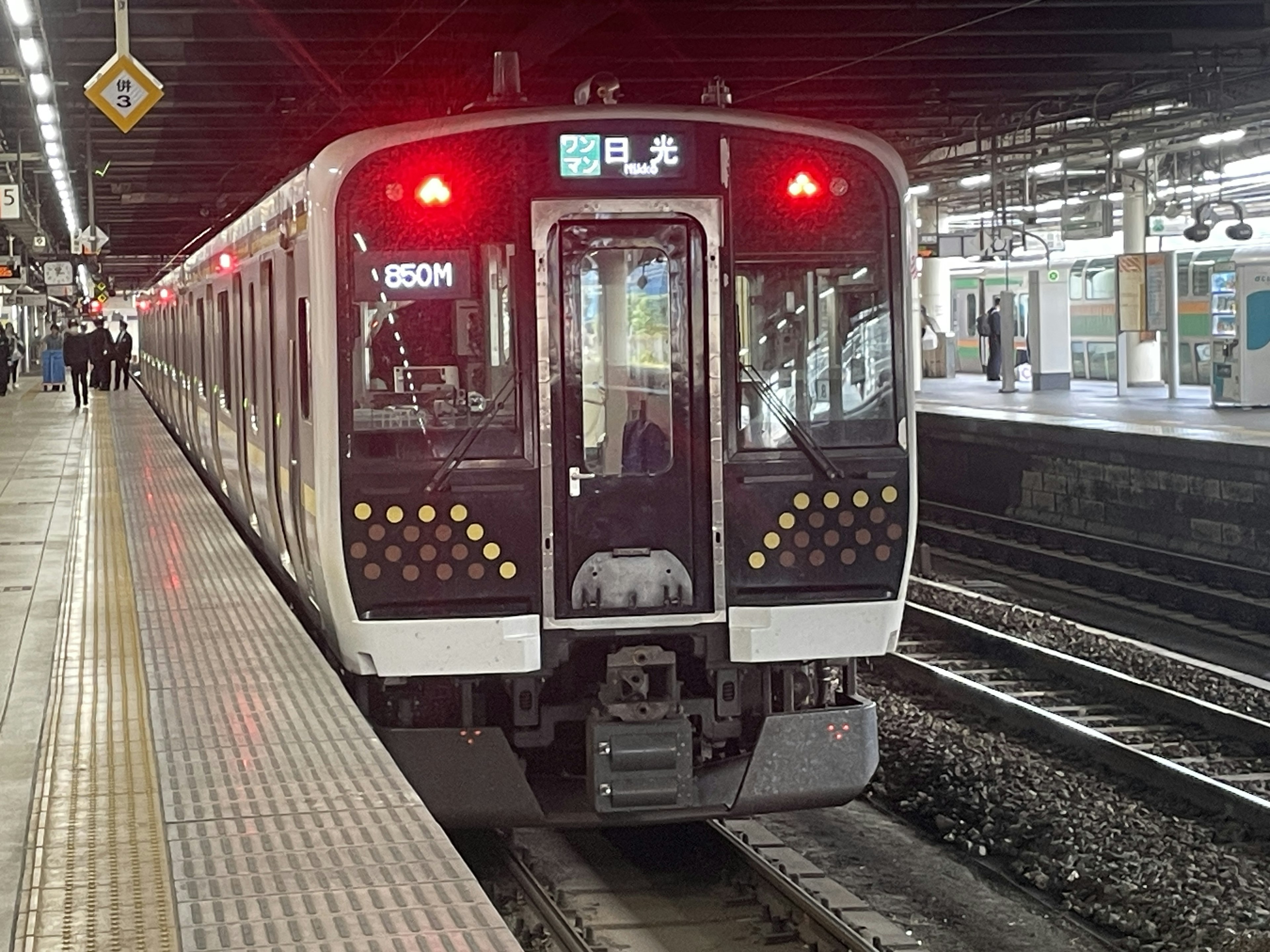 Zug am Bahnhof mit eingeschaltetem roten Signallicht