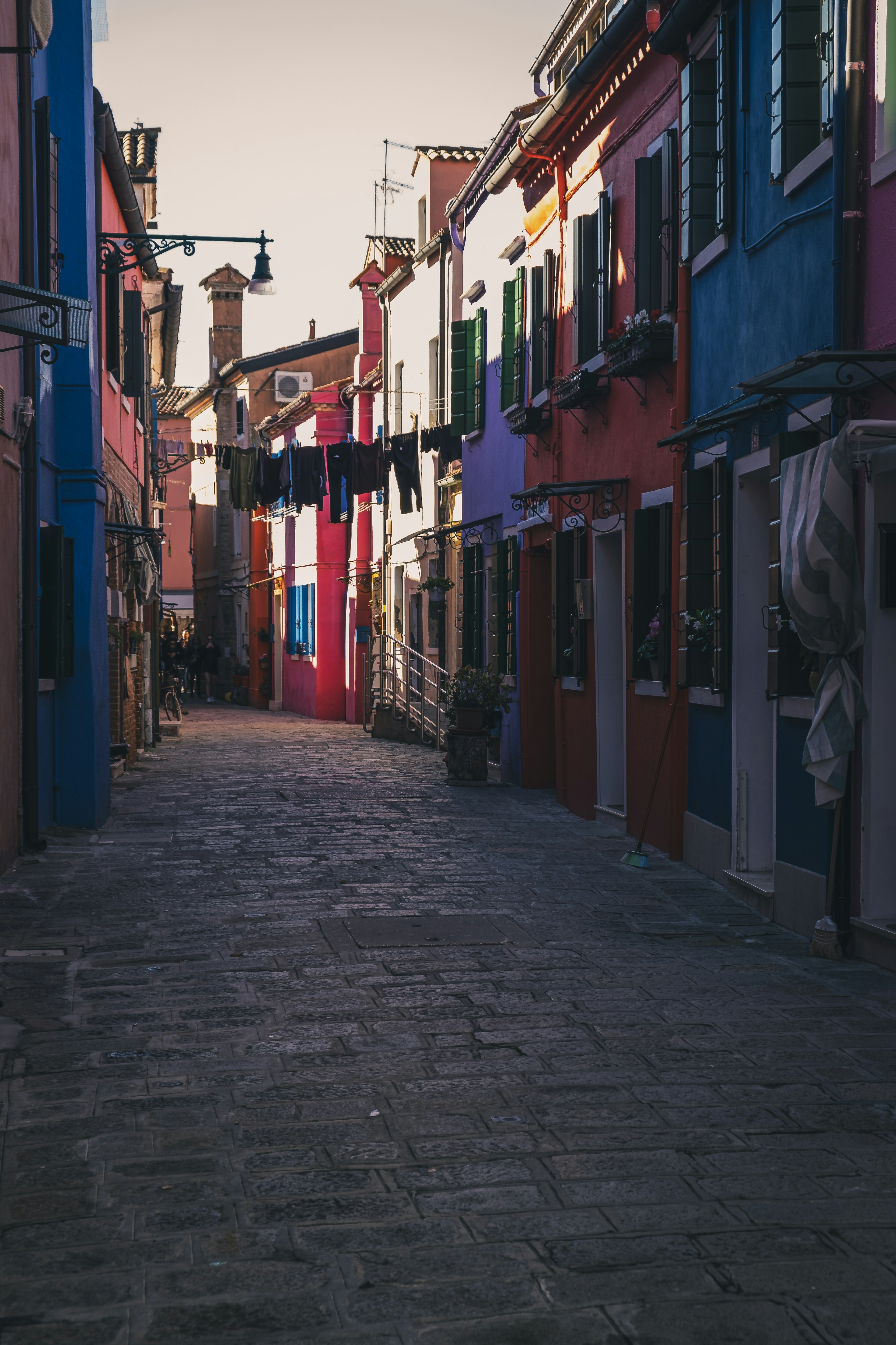 Quiet street lined with colorful houses and hanging laundry