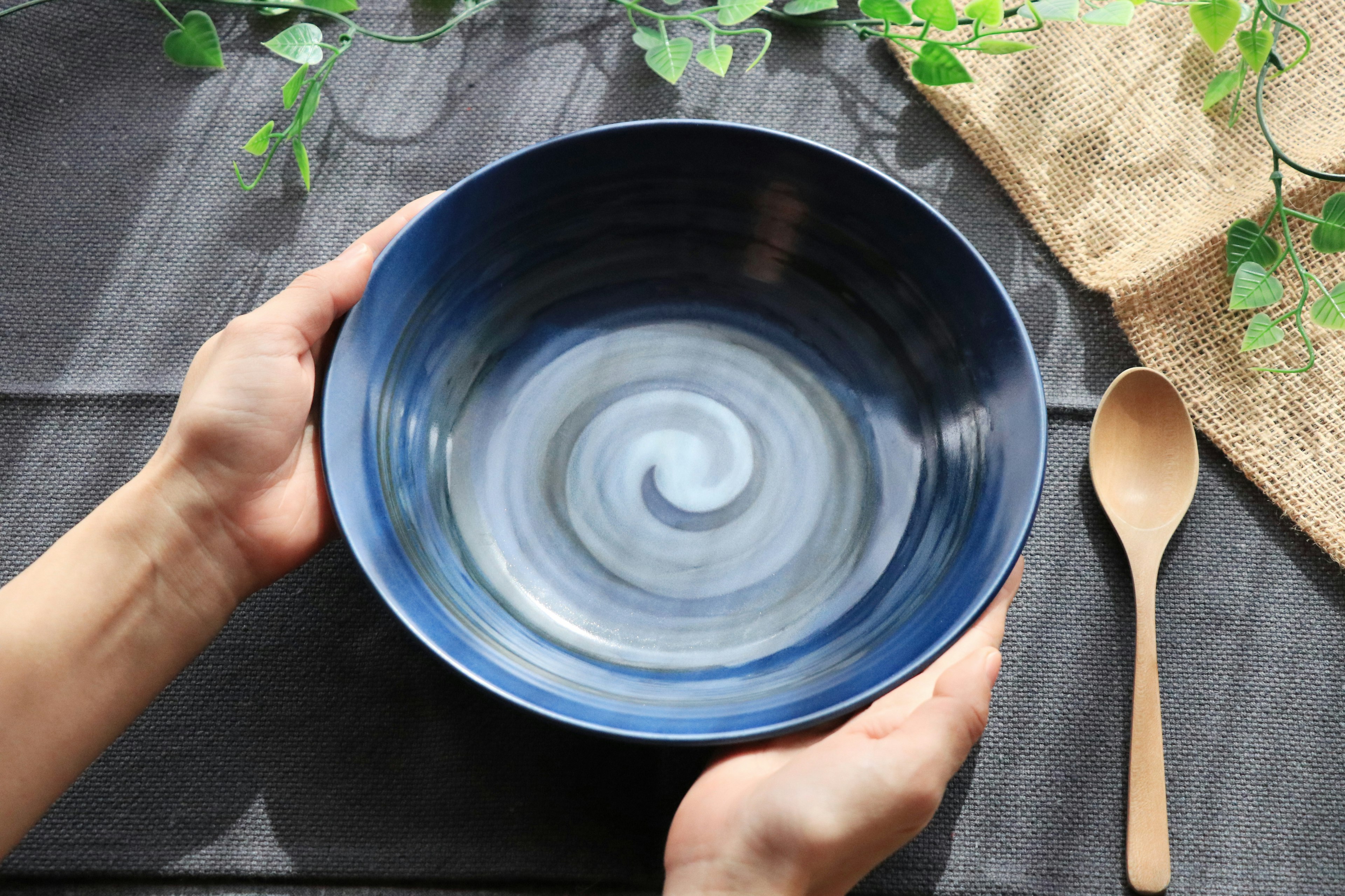 Hands holding a blue swirling patterned bowl