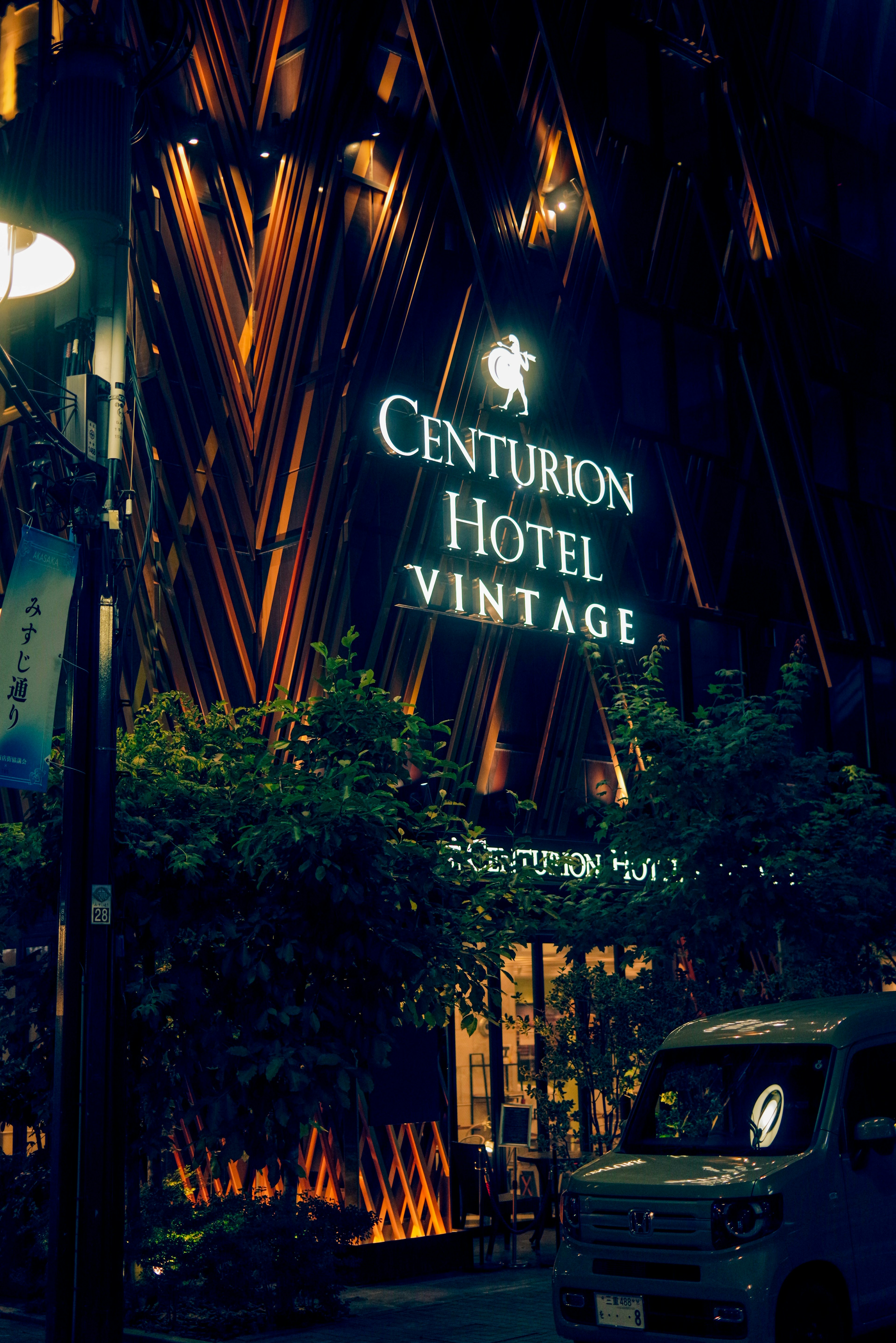 Centurion Hotel Vintage exterior at night featuring illuminated sign and greenery