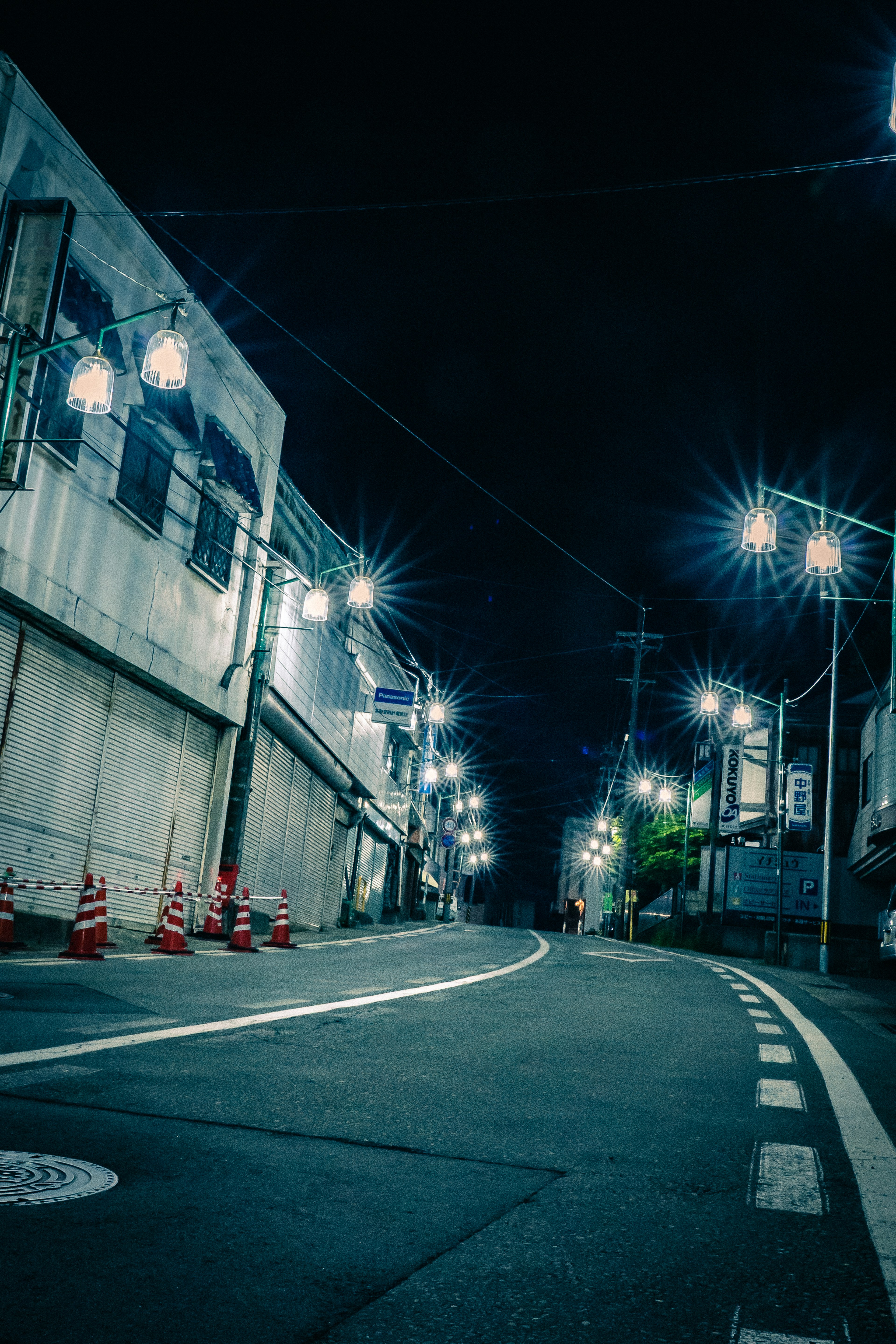 Strada vuota di notte illuminata da lampioni