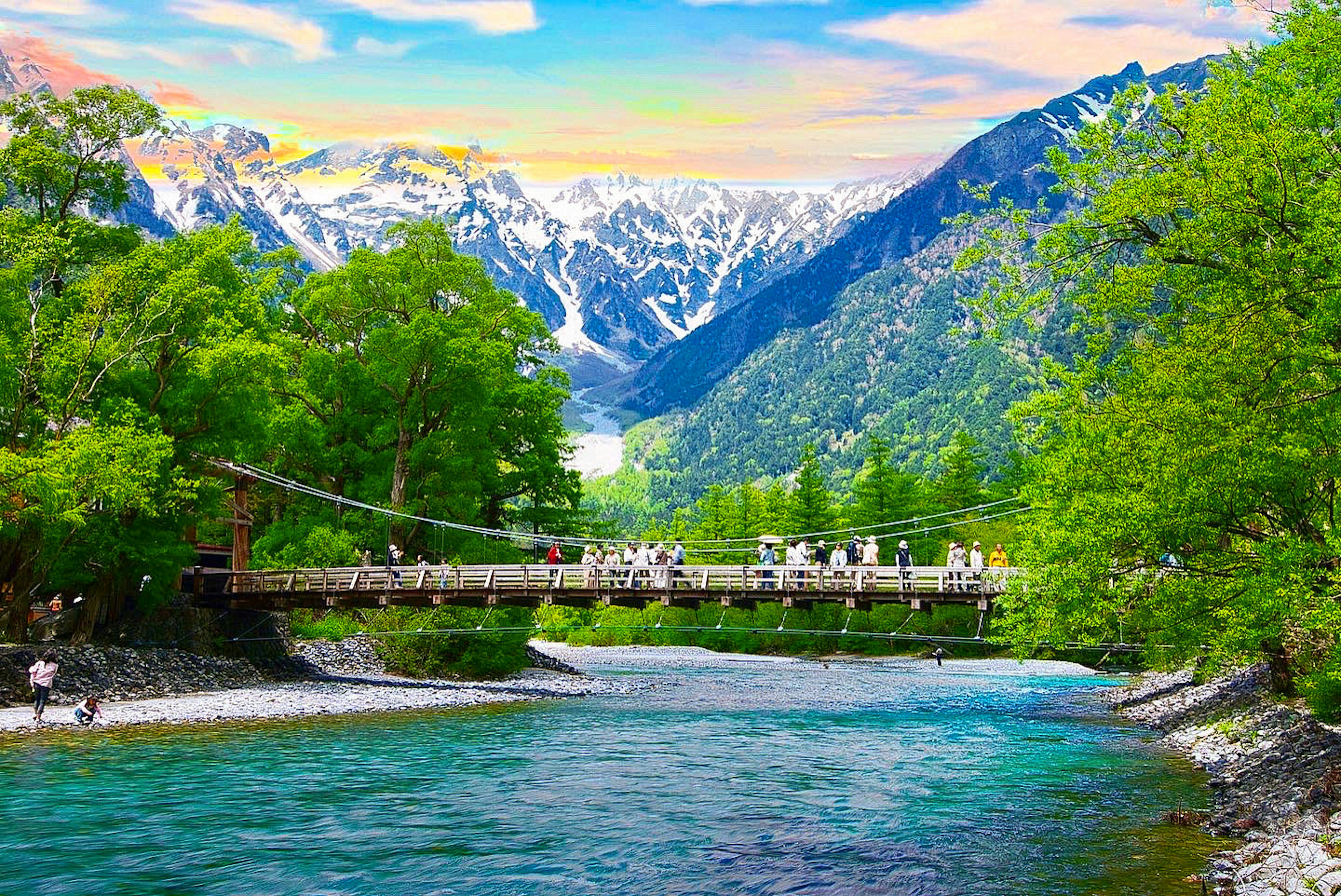 Vista panoramica di un fiume con un ponte sospeso circondato da montagne