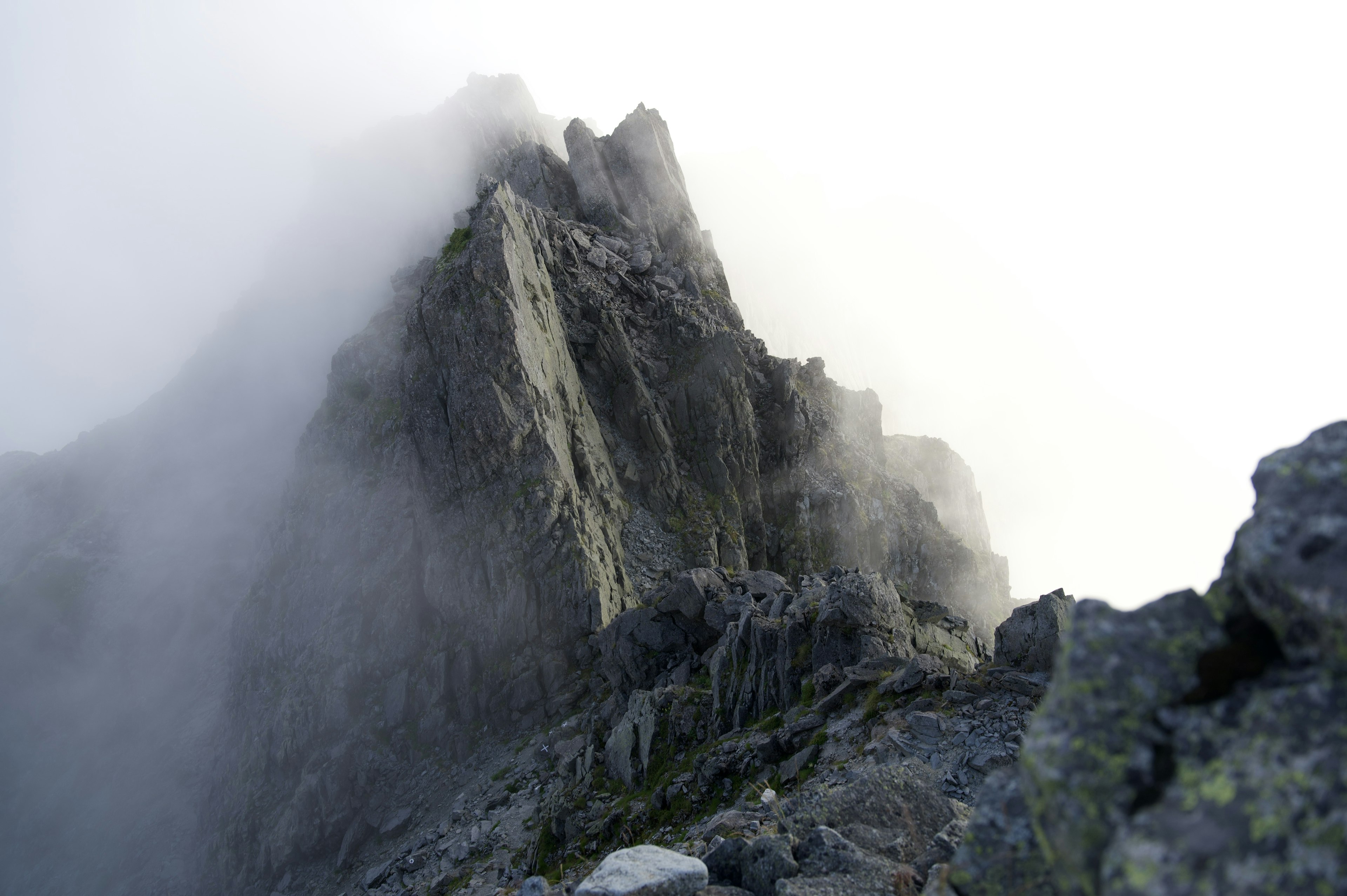 Sharp mountain peak rising through fog