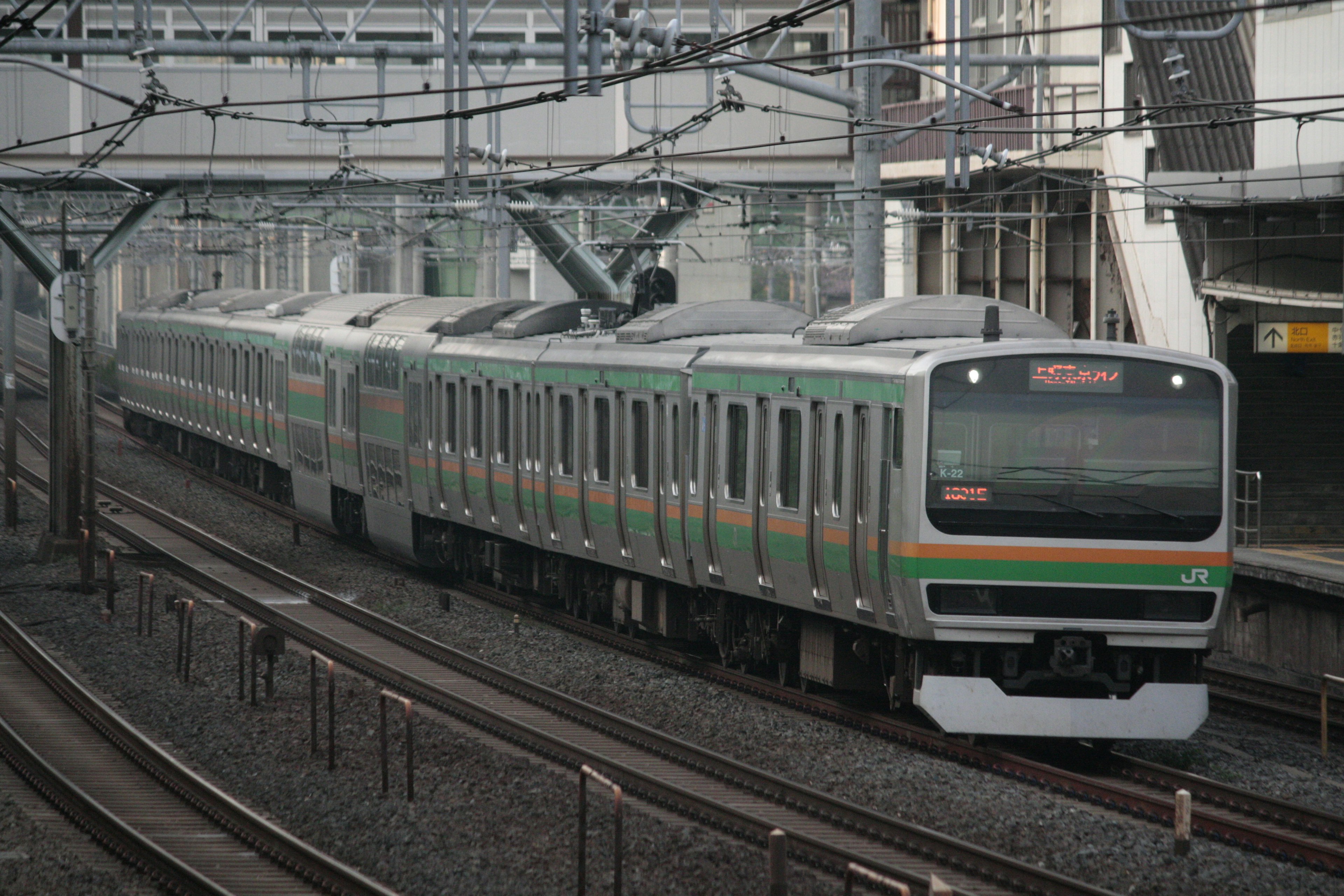 一列日本火車在軌道上行駛，配有電纜